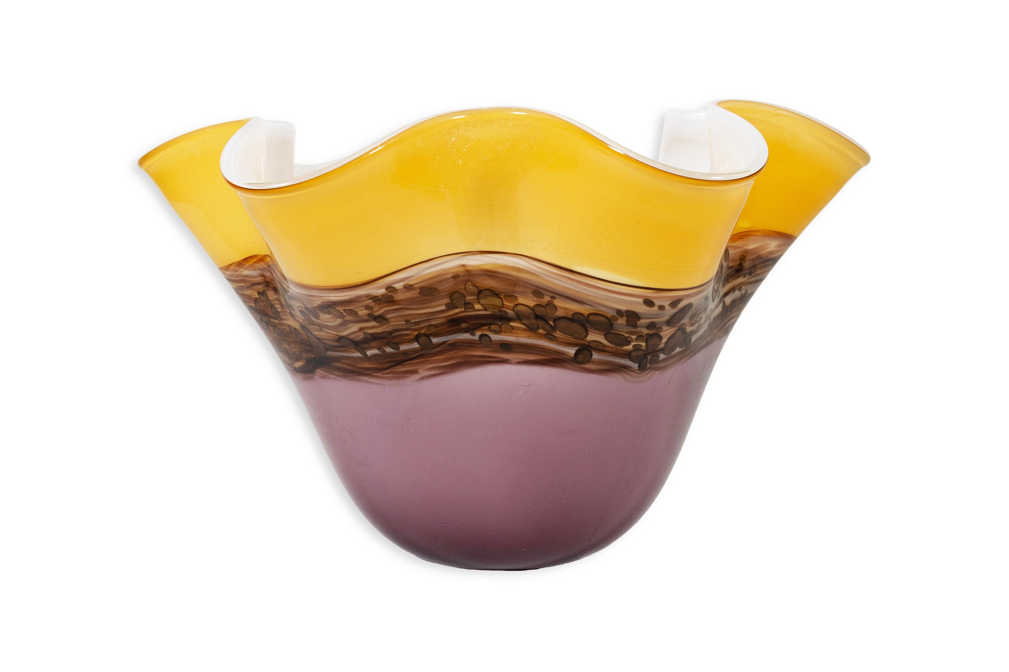 Vaso in vetro soffiato a mano viola e giallo di Viz Glass Inc. Questo piccolo vaso di vetro può essere utilizzato come vaso o ciotola per qualsiasi tavolo della tua casa. Il design astratto del vetro conferisce al pezzo una qualità stravagante. Il