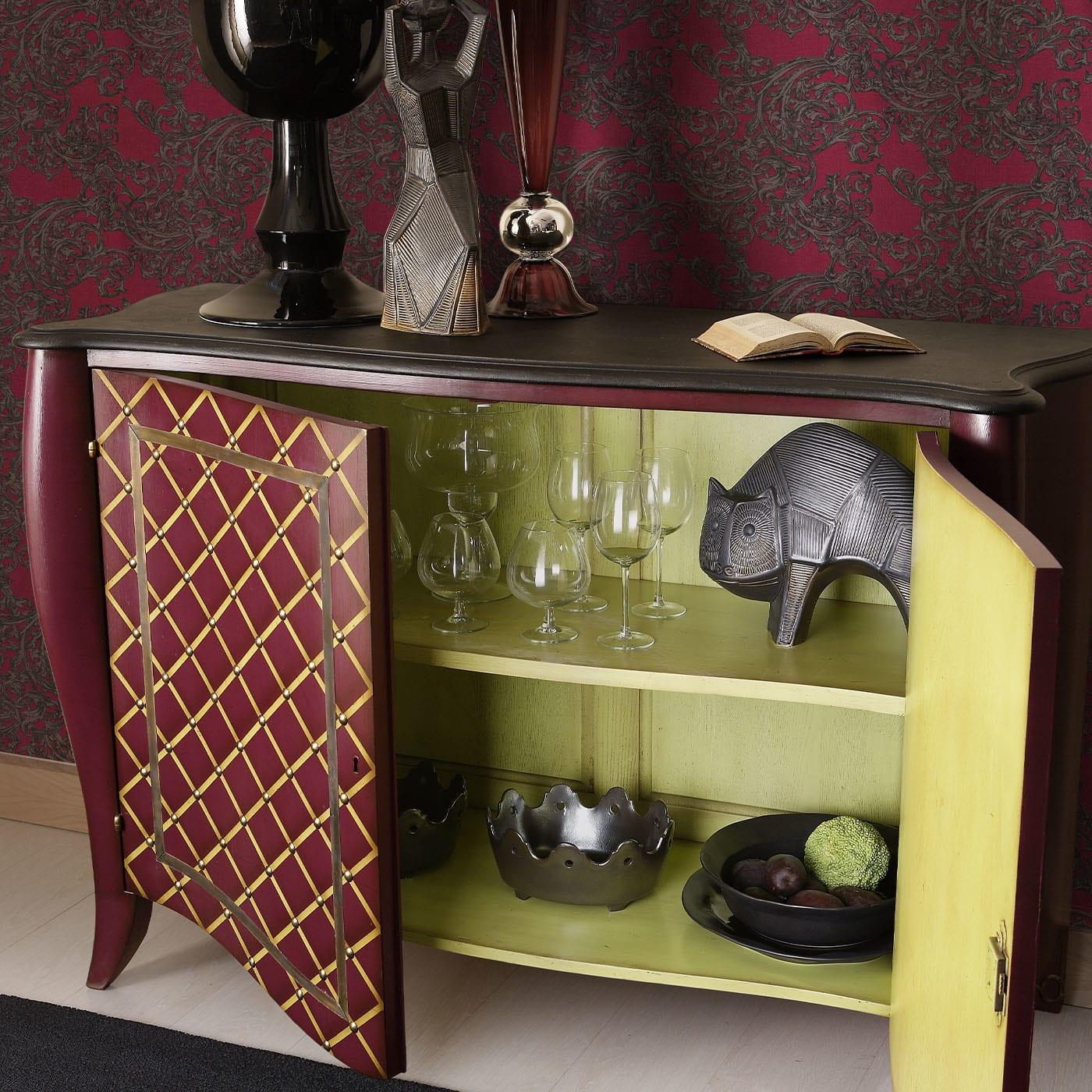 Marked by a yellow diamond pattern accented with studs, this sideboard boasts a wooden frame traced by sinuous and harmonious lines and finished in a glamorous tone of purple. Brass frames accent the two doors, which open to reveal a wide storage