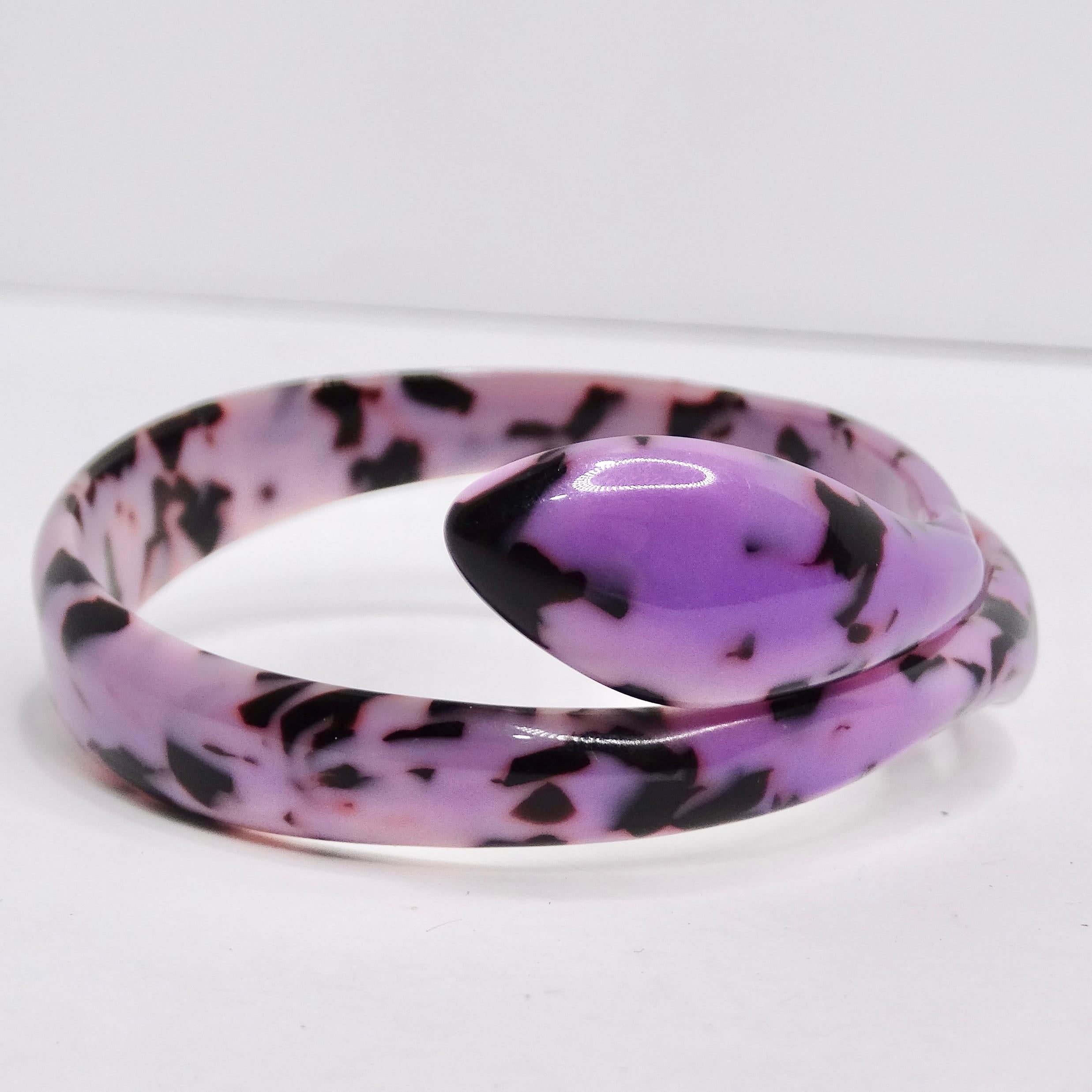 Unleash your inner serpent enthusiast and elevate your style with our exquisite Purple Bakelite Snake Head Cuff Bracelet. Crafted in the 1980s, this striking cuff bracelet is a true masterpiece, combining gorgeous purple bakelite with intricately