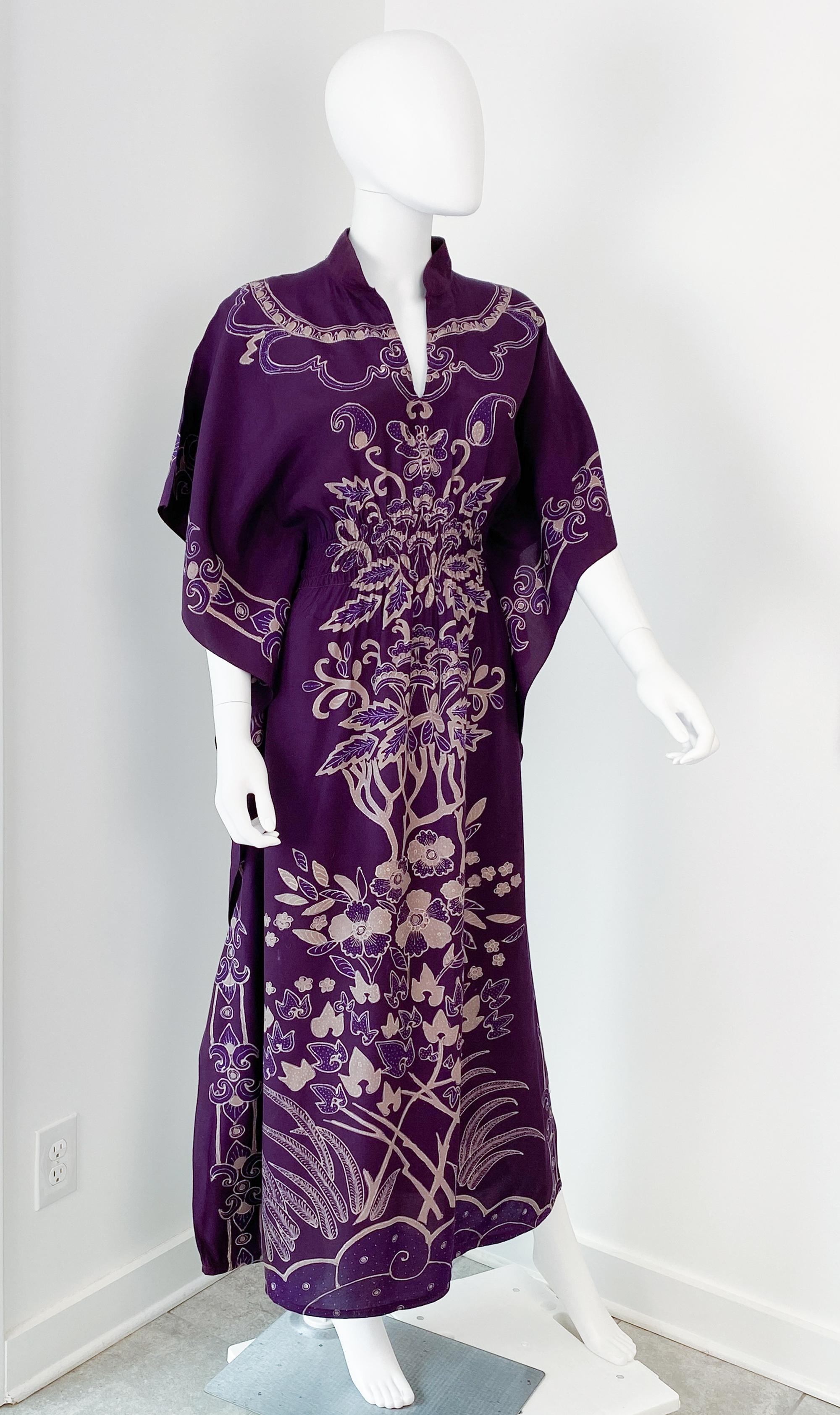 Maxi abito caftano vintage anni '70 in tessuto batik con maniche a pipistrello.
Esempio di eleganza bohémien anni '70, questo maxi abito caftano etnico vintage emana energia vibrante e dettagli artigianali. Realizzata in cotone setoso, la luminosa