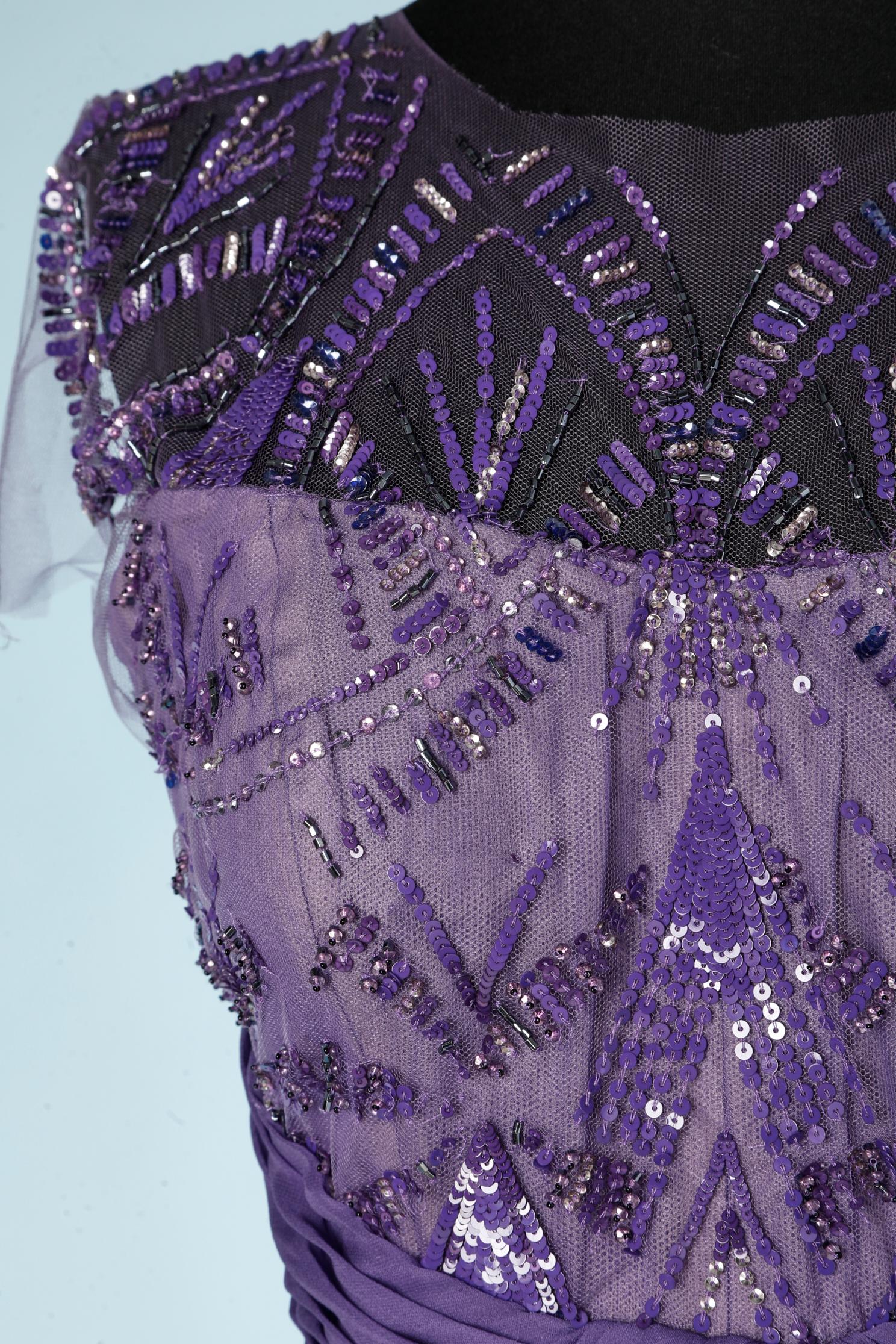Abito da sera viola drappeggiato in vita con abbellimenti di paillettes. Tessuto principale e fodera: 100% seta. Tulle di poliestere. 
Barra imbottita e disossata. Chiusura con zip al centro della schiena e un gancio superiore. 
Sfrangiato in vita e