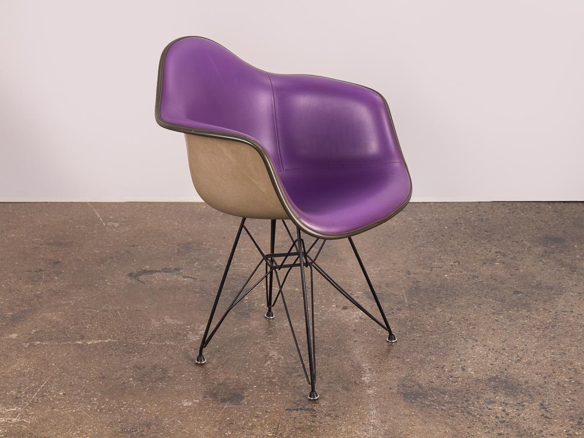 1960s Padded Eames Armshell Chair on the black eiffel base. In a stylish, rare purple color! The padded vinyl is in good condition, very clean with only a small closed tear on the bottom right. Add a classic touch of midcentury to any room with this