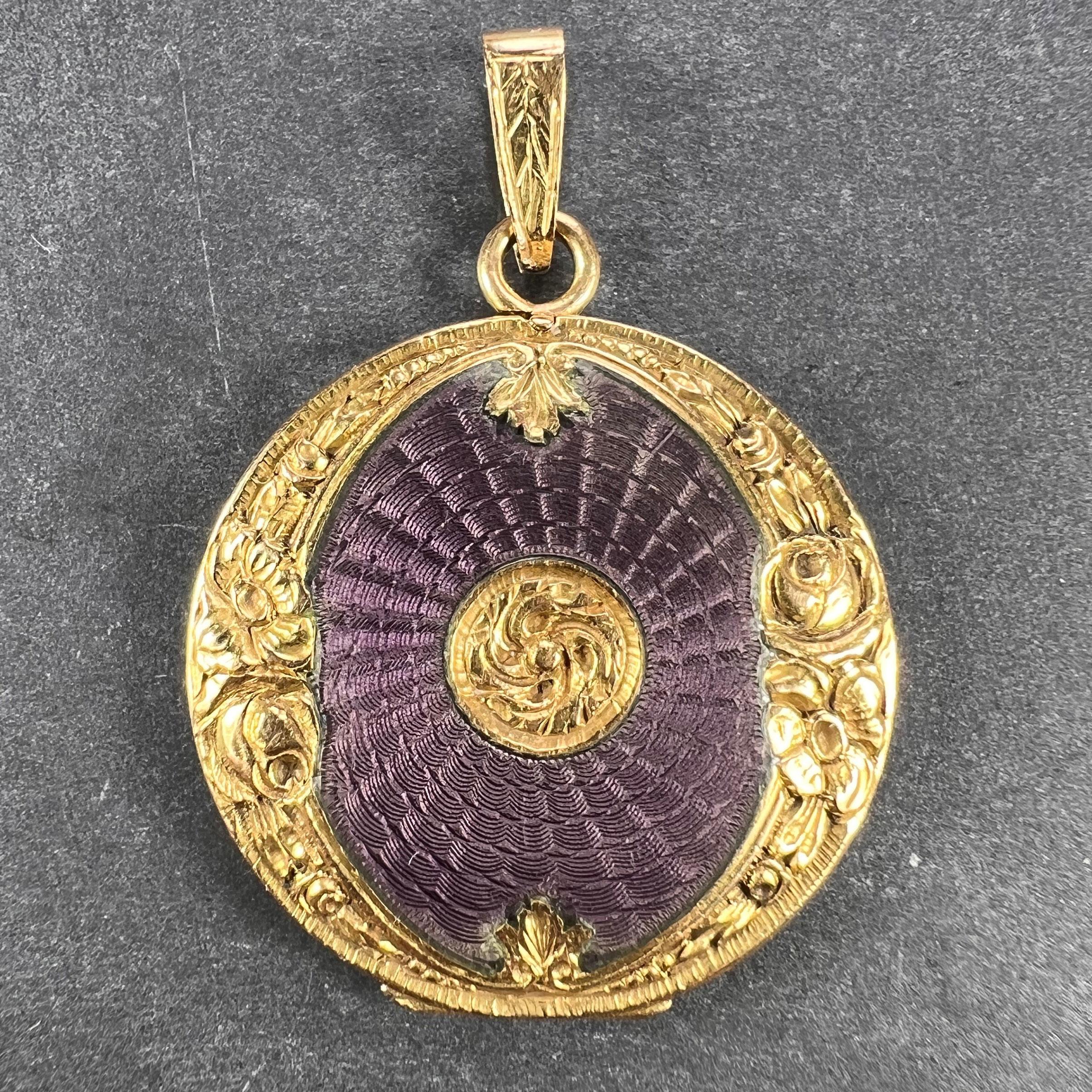 An 18 karat (18K) yellow gold pendant locket with purple guilloche enamel and a floral frame. Scratch numbered 028. Unmarked but tested as 18 karat gold.

Dimensions: 2.8 x 2.4 x 0.35 cm (not including jump ring)
Weight: 5.99  grams
