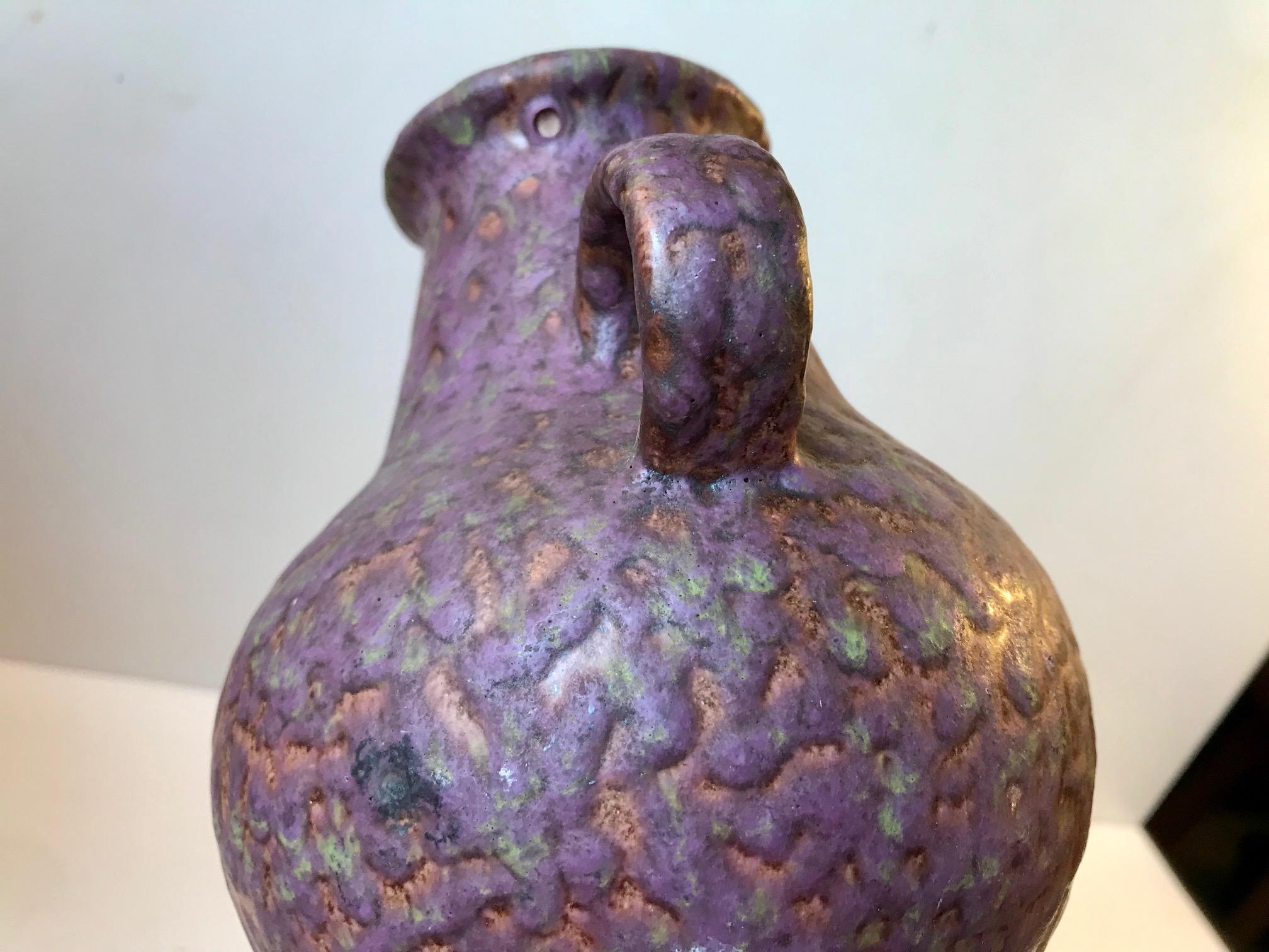 Unique looking vase covered all over in a mixed fatlava glaze of purple, rose and greens nuances. Designed and made by Dumler & Breiden in Germany during the 1970s. Imprinted/signed by maker and numbered: 302/21 - 74.