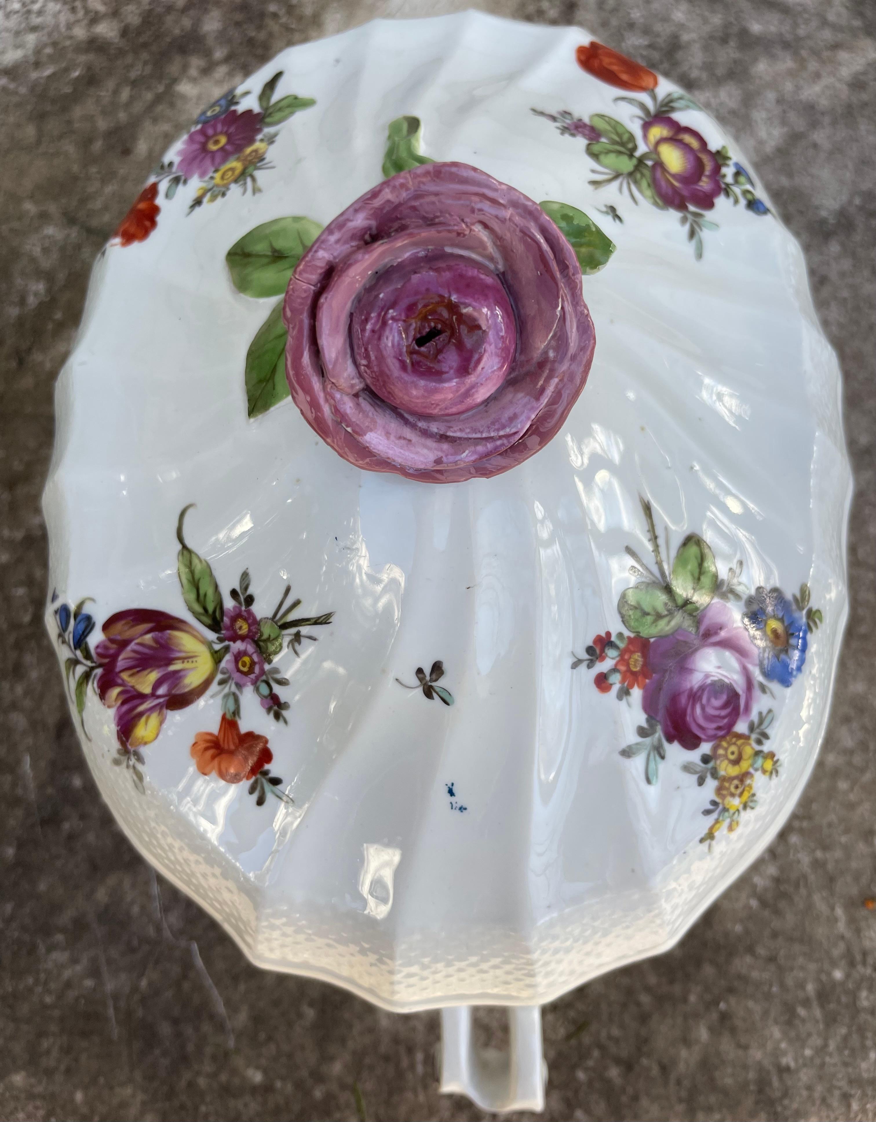 Purple floral tureen. Vienna covered serving dish of ovoid form with sigillated outflowing ribs with wicker borders and tendril-like scroll handles. A fine medium size serving piece with large floral sprays in puce, topped by a large purple rose