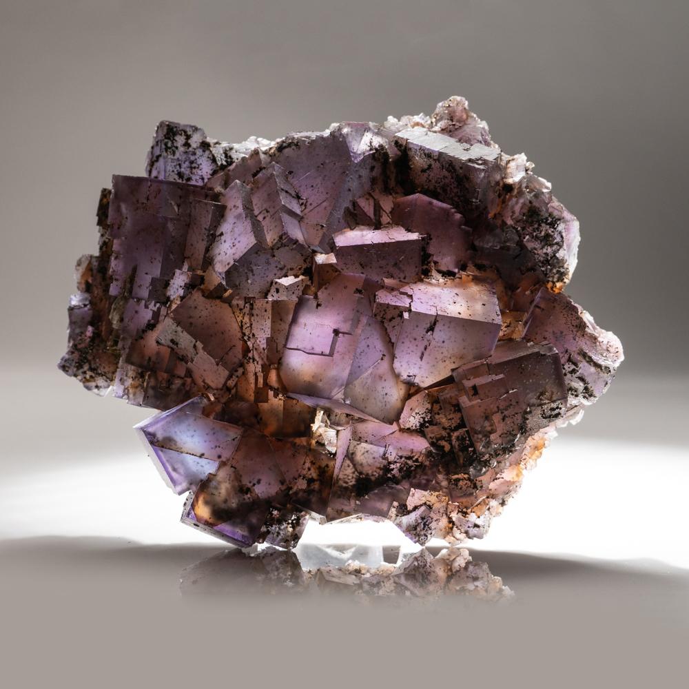 Transparent 3D cubic purple fluorite crystals overgrown atop a cluster of lustrous sphalerite crystals on matrix. The fluorite has rich purple zoning outlining the crystal faces.

4.8 lbs, 3 x 2.5 x 1.5 inches.