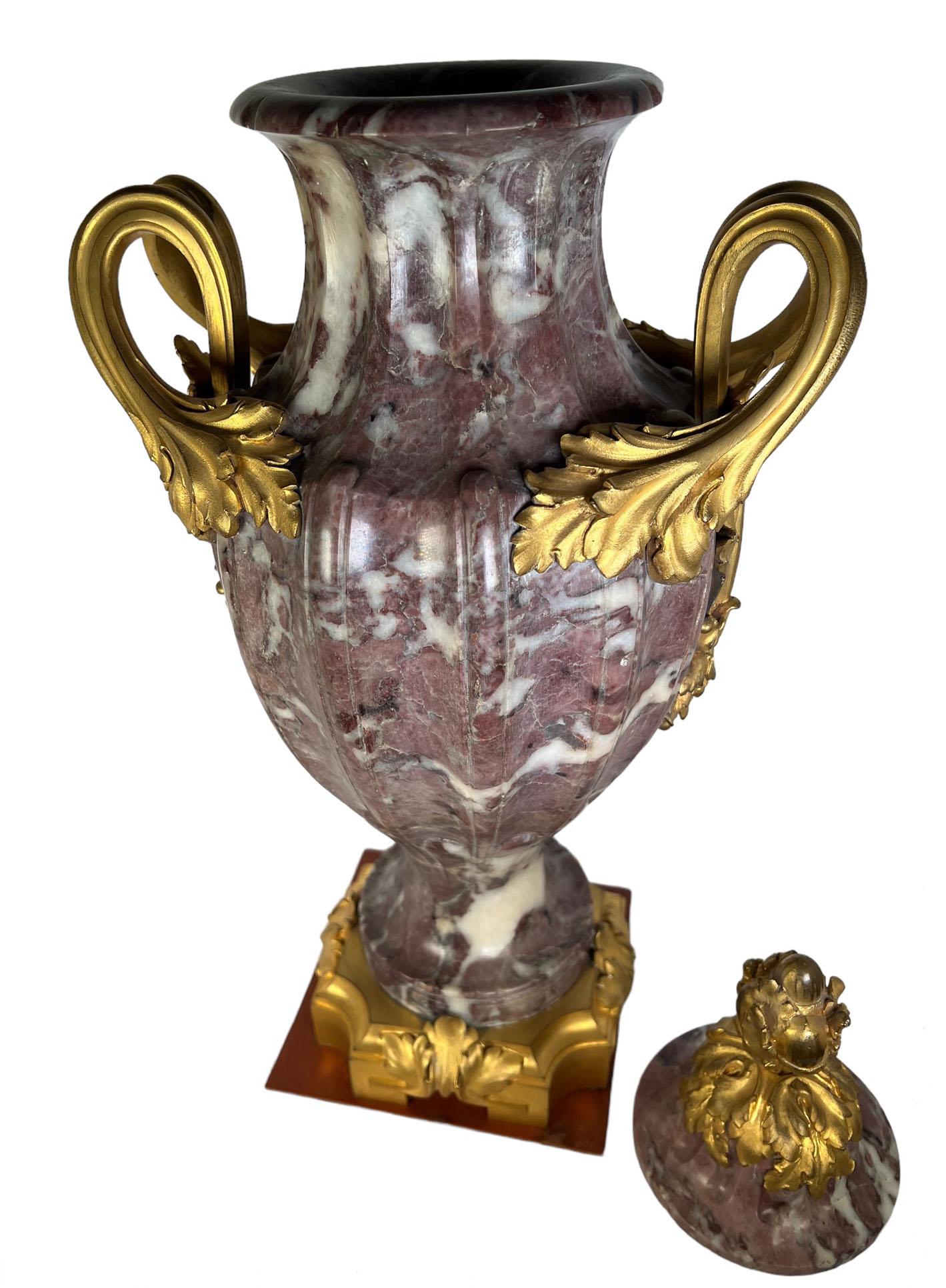 A purple fluted marble urn with bronze dore mounts, handles and lid. Theres a Paris, France foundry mark and signature on the base by F. Rambaud. Circa 1870.