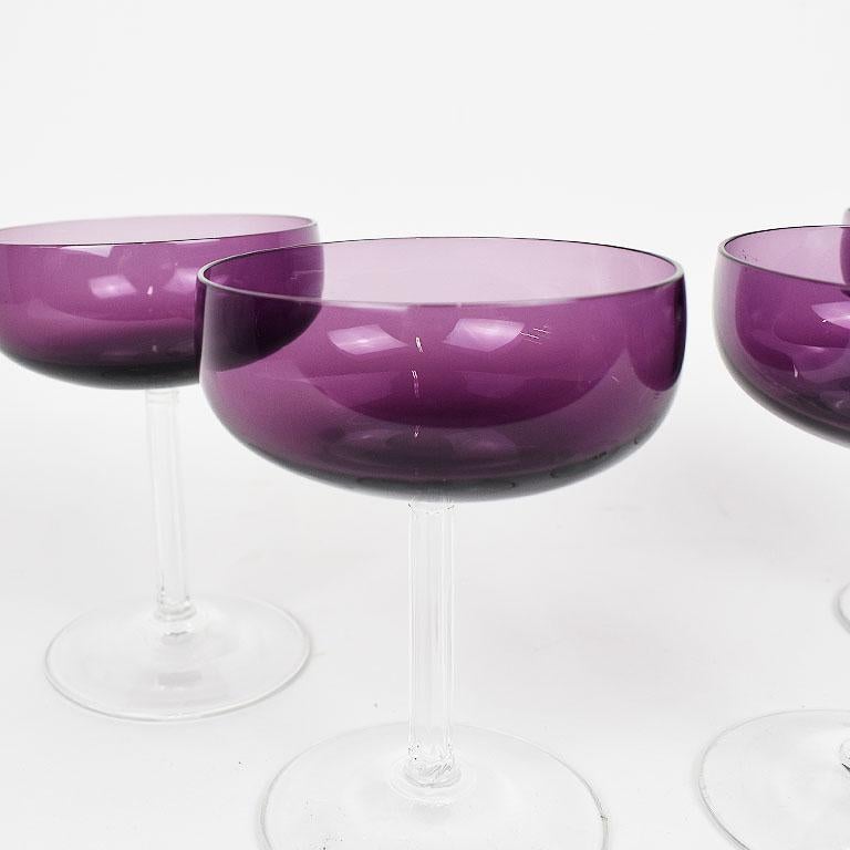 A set of beautiful purple translucent Fostoria champagne coupe glasses. Each glass has a short body and is in a pretty deep purple. The base of each cup is clear with a faceted stem. 

Set of 4
Measures: 3.5