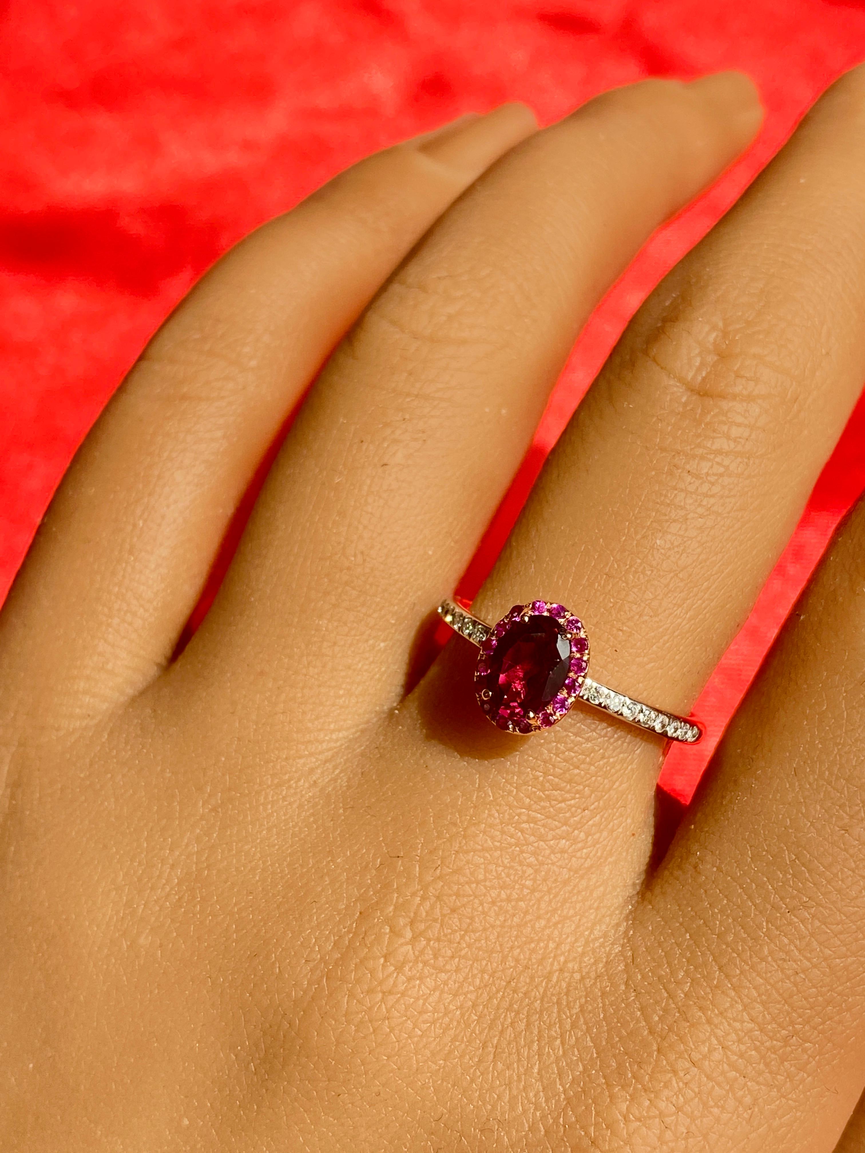 Notre bague en grenat violet ! La pierre centrale est un magnifique grenat rhodolite ! Le halo est composé de merveilleux rubis rouges, et la tige est ornée de diamants blancs ronds ! Il s'agit d'une bague unique avec des couleurs chaudes qui se