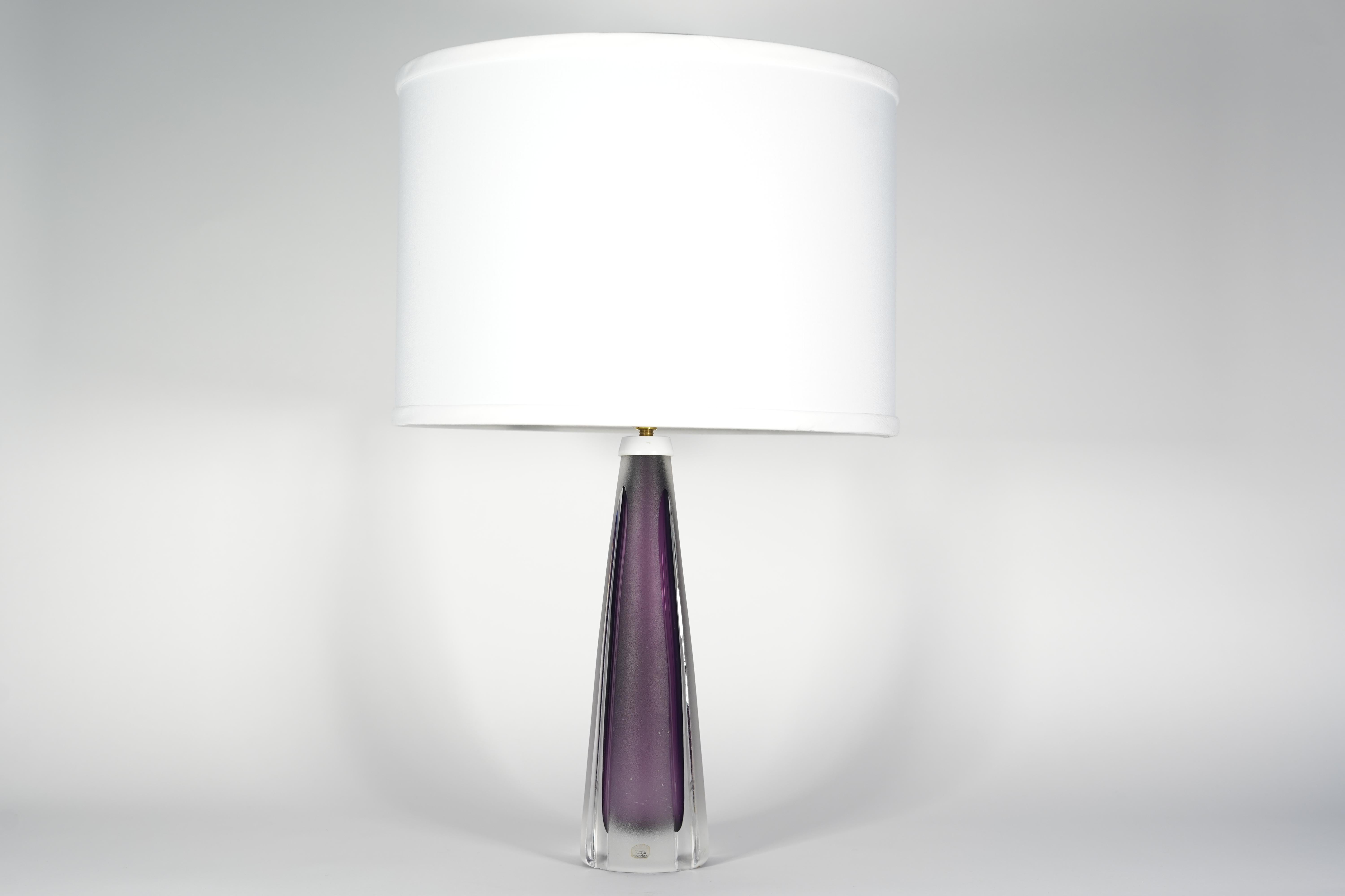 Purple and clear glass lamp by Kosta, Sweden, 1980.
Partly frosted and a purple core glass encased in smooth clear glass with partial frosting , the base is very heavy as it is all glass just the inner core is hollow, signed Kosta and still has