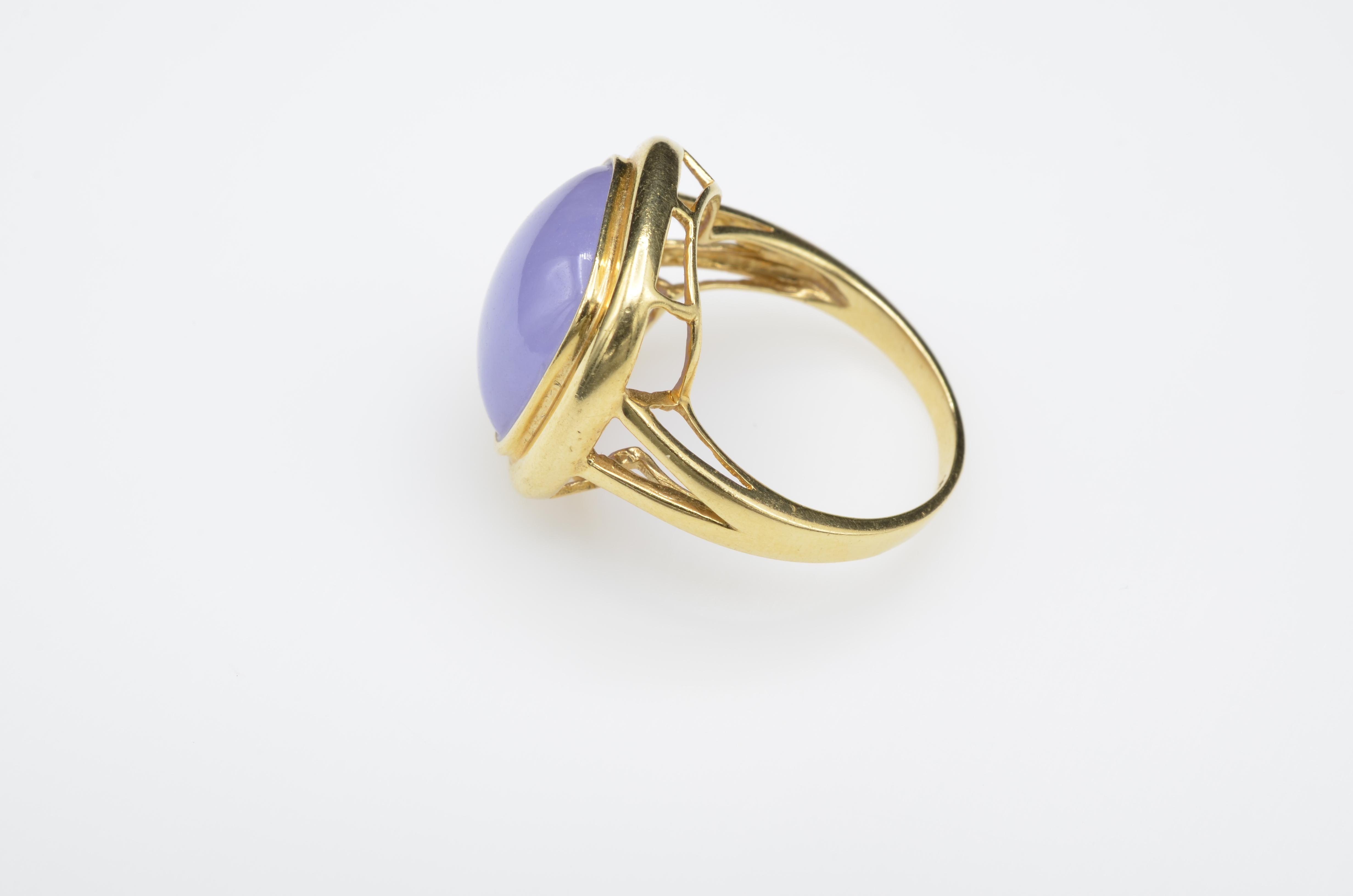 This beautiful lavender jade ring is set in 14K yellow gold and most likely dyed giving it a warm and bright shade of purple. Set in an architectural design this ring is comfortable to wear given its substantial size. Size 9.25 and may be sized. 