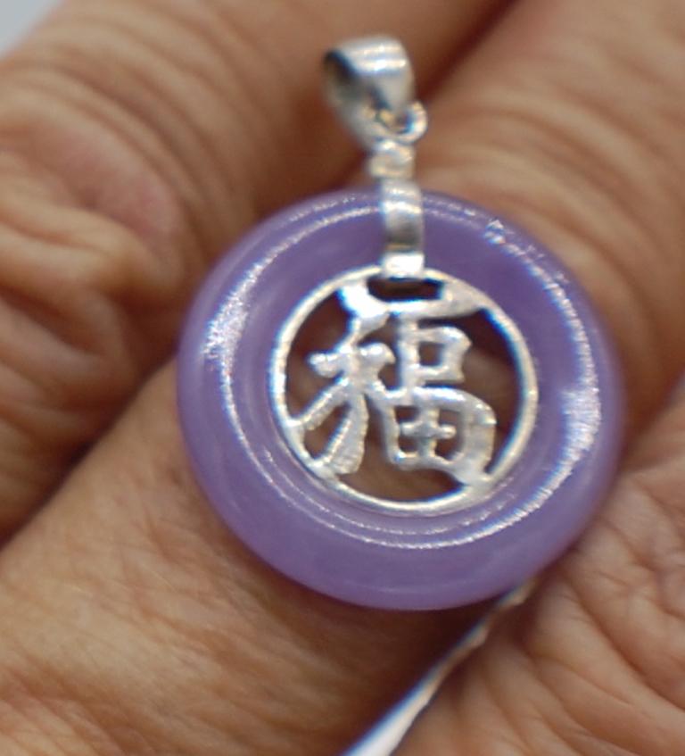 Lavender Jade Purple Chinese Pendant Good Luck 

This is a very sweet pendant which exhibits a strong lavender color. The silver colored metal is a great contrast against the purple color on this 20 mm in diameter pendant. The length total with the