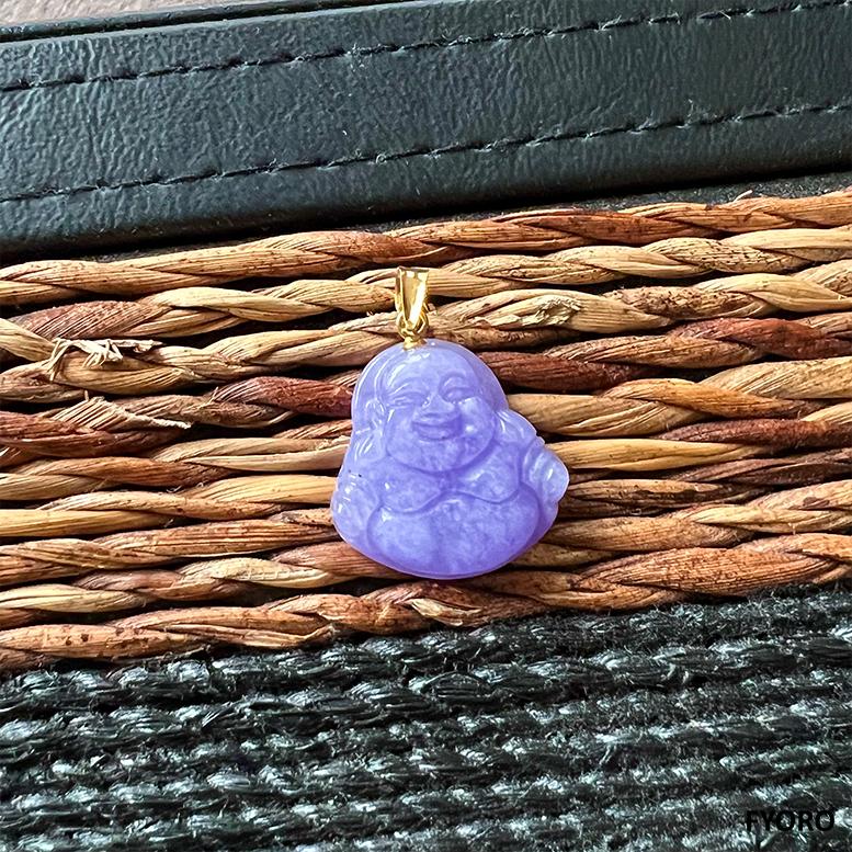 The 'Cha'an (Purple) Jade Laughing Buddha Pendant' takes inspiration from the traditional laughing Buddha figure that originates from Zhejiang. This iteration portrays Gautama Buddha laughing yet with a peaceful demeanor. Our masterpiece uses FYOROs
