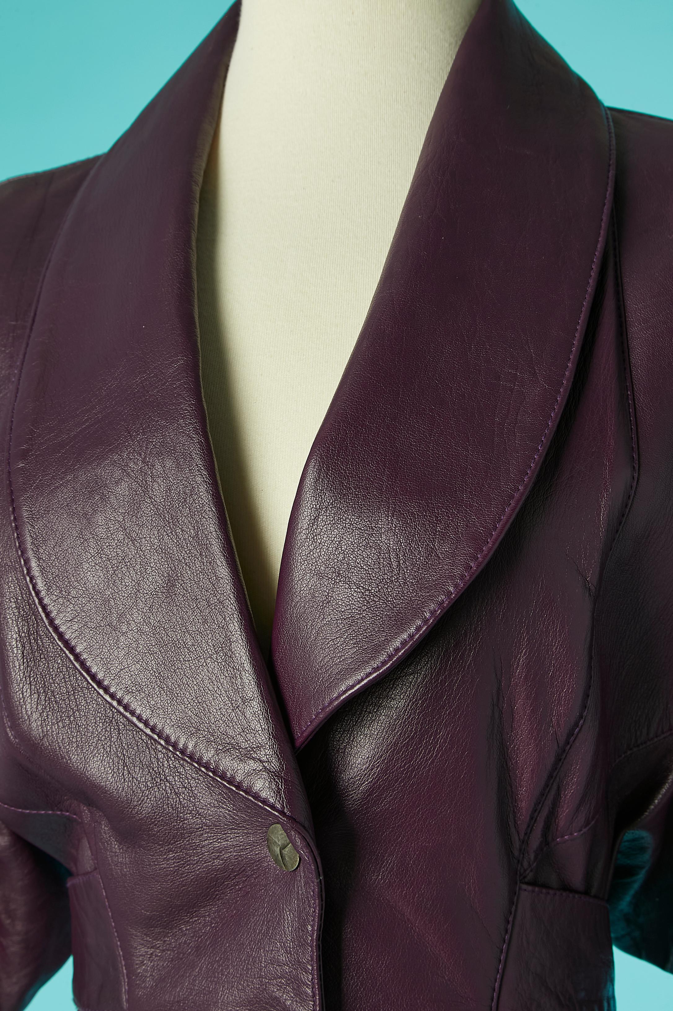 Purple leather dress with metallic snap in the middle front . One pocket with zip on the right side. Rayon lining. Shoulder-pads. Half- belt with buckle closure in the middle back. 
SIZE S 