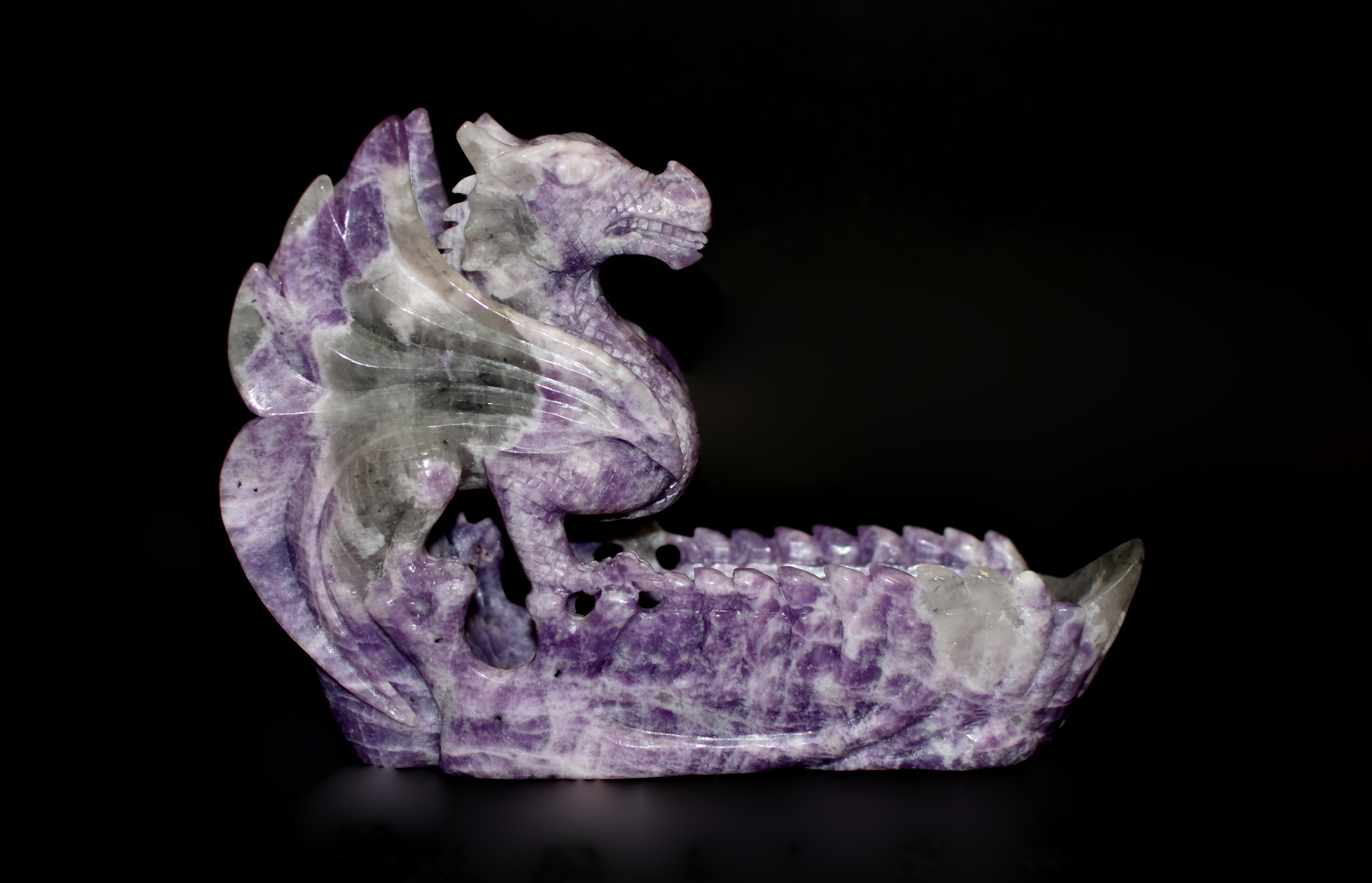 Crafted from 100% natural, finest grade lepidolite, this finely carved 3.4 lb sculpture captures the magnificence of the dragon via a beautiful rare mineral. With scales gleaming and bulging eyes that flicker, the dragon commands both fear and