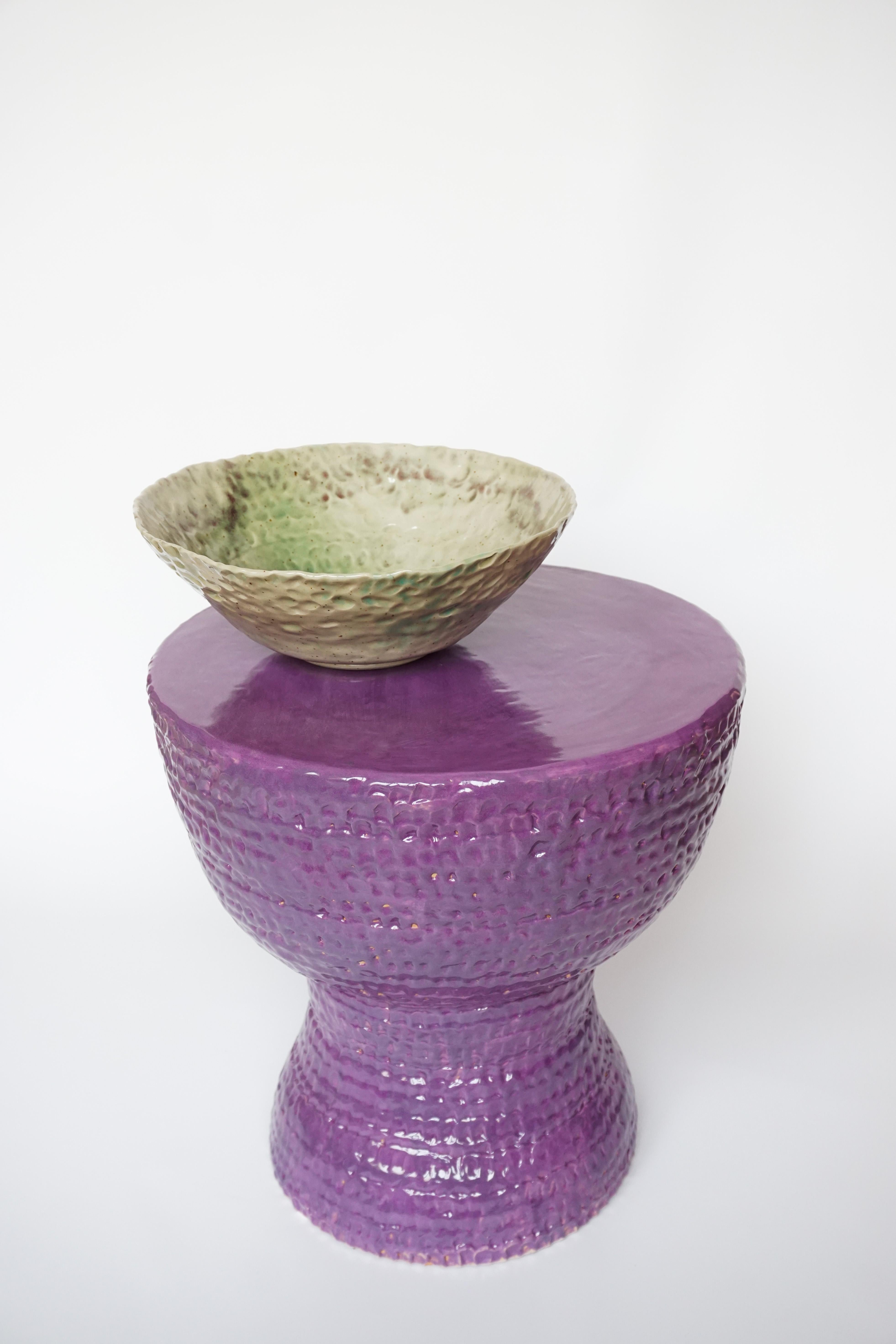 Purple Lipstick Taburette & Green Bowl by Arina Antonova
Dimensions: H 40 x D 35 cm
Materials: terracotta, glaze, pigment.

Born in Sewastopol (Crimea), I was surrounded by the natural variety of the coastal Black Sea views with rocky beaches and