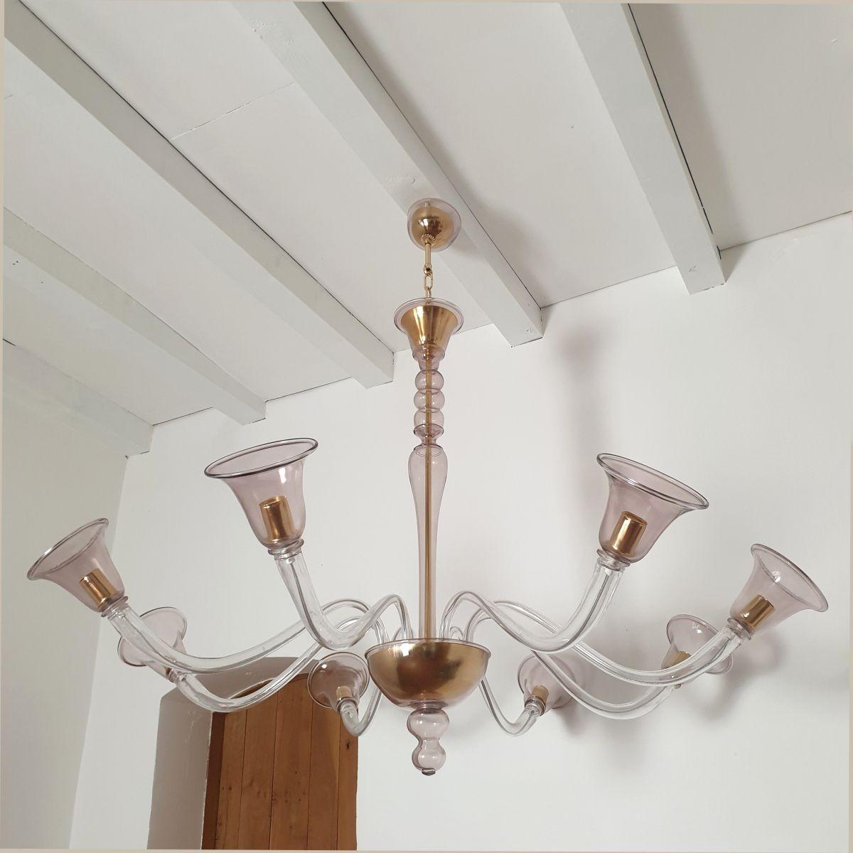 Large Mid-Century Modern Murano glass chandelier, Seguso style, Italy, 1980s.
The hand blown chandelier is made of a thin delicate light purple color Murano glass.
The chandelier has gold plated mounts.
It has a double canopy, with a gold plated