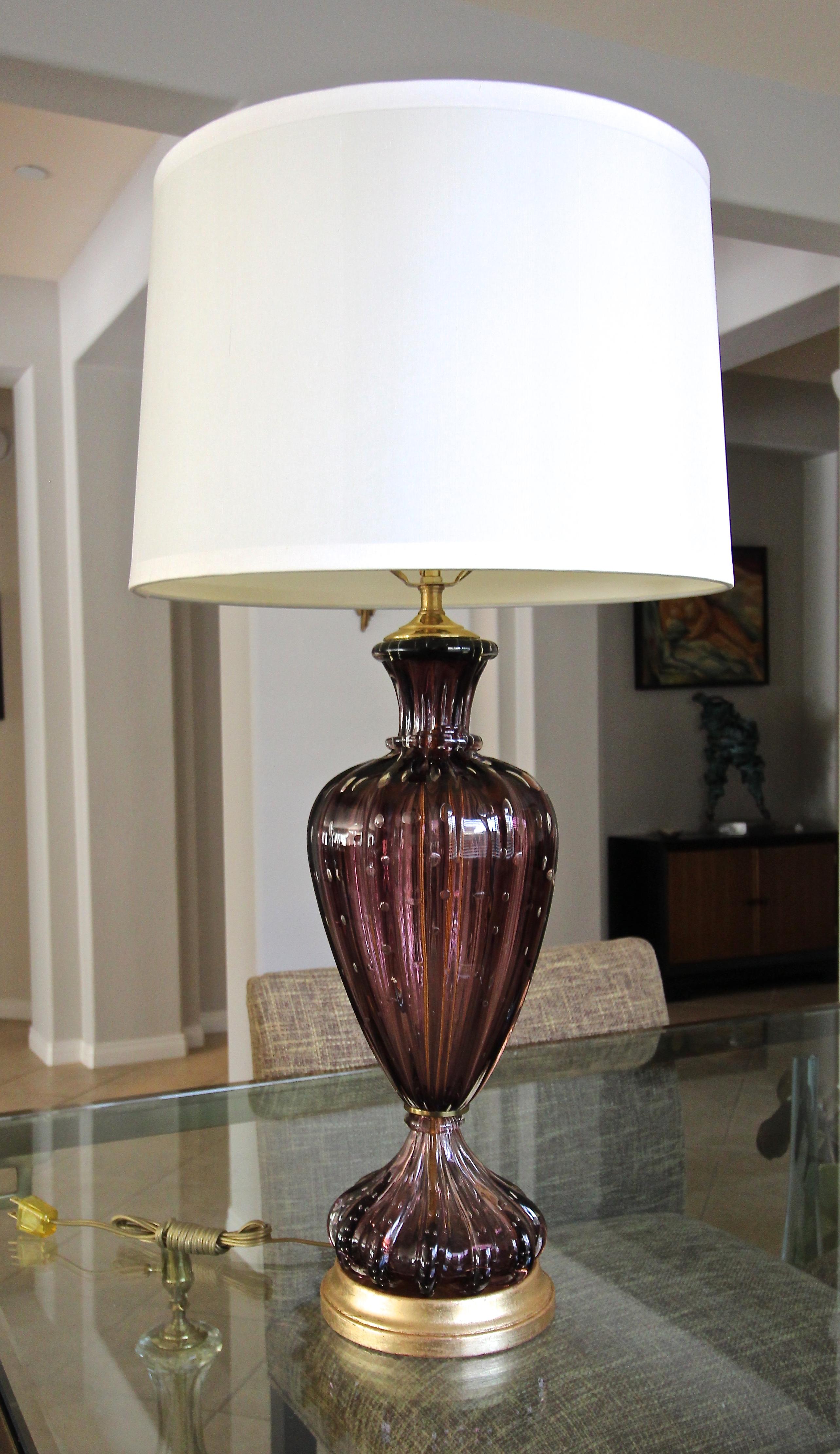 A single Murano hand blown purple glass table lamp. The glass is ribbed with controlled bubbles and mounted on new custom giltwood base. Newly wired for US with new solid brass fittings, 3 way socket and cord.

Height to top of class 18.5 