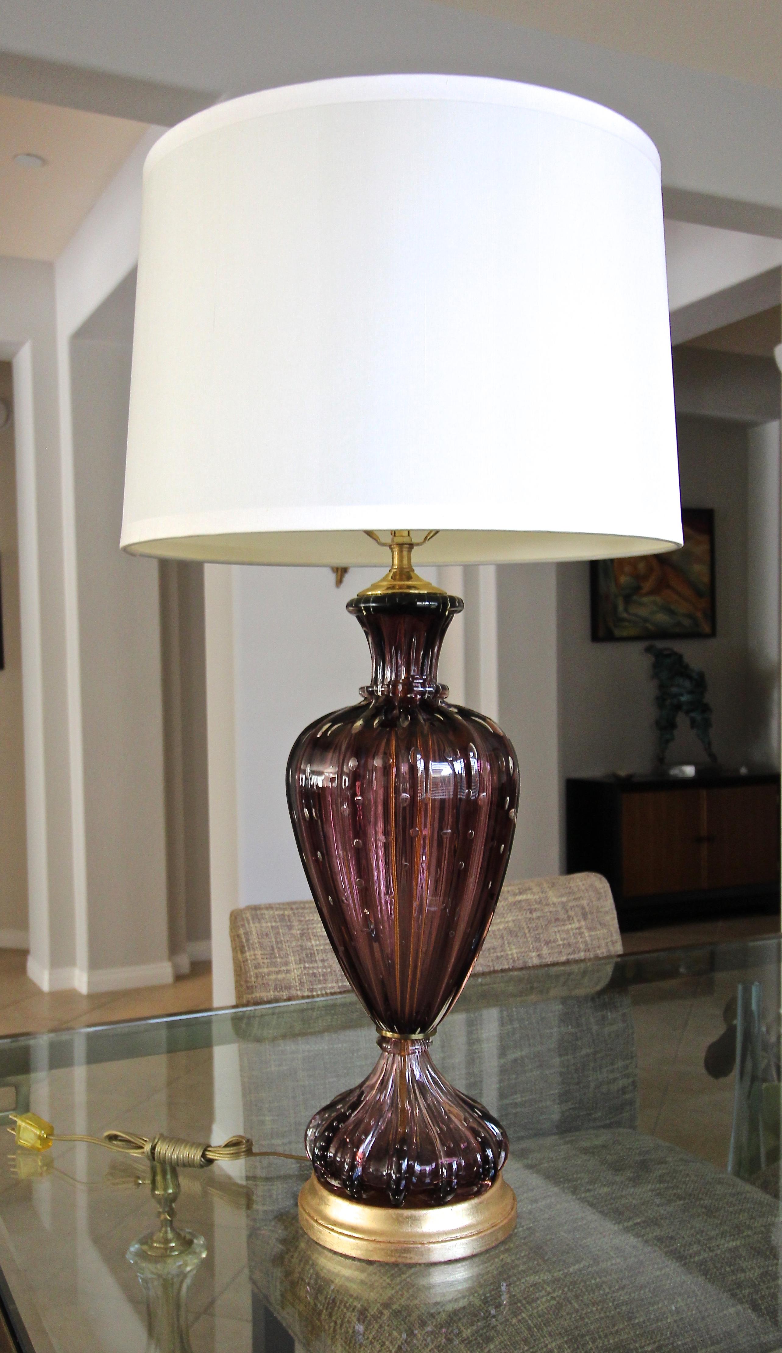 Une seule lampe de table en verre violet soufflé à la main de Murano. Le verre est nervuré avec des bulles contrôlées et monté sur une nouvelle base en bois doré personnalisée. Nouvellement câblé pour les États-Unis avec de nouveaux raccords en