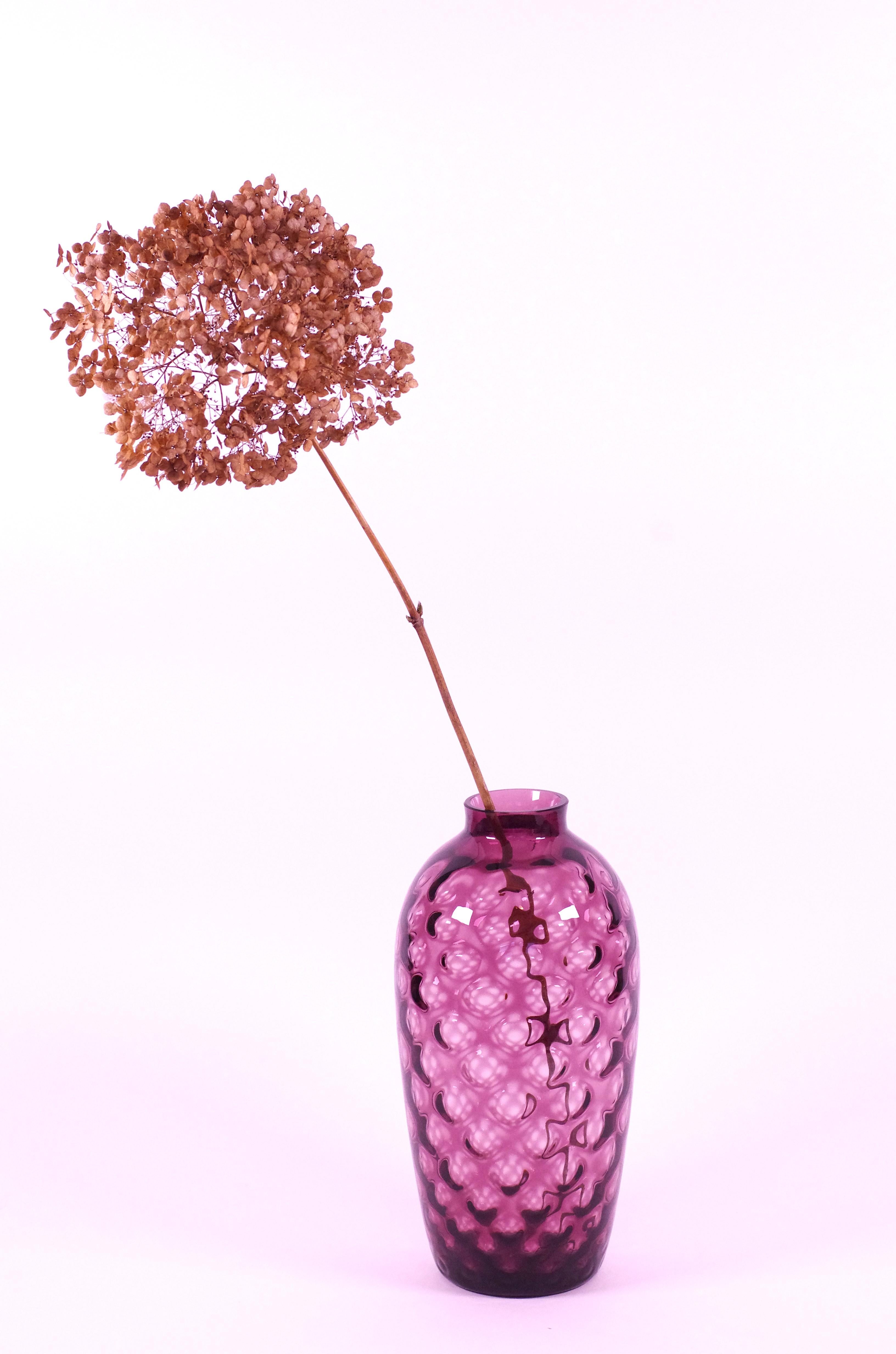 Product description:
This vase, by Borske Sklo, combines a nice summerish color with an elegant form. The vase suits a single (larger) flower but could hold a colourful bouquet as well. The color of the vase lies between pink and purple, more light