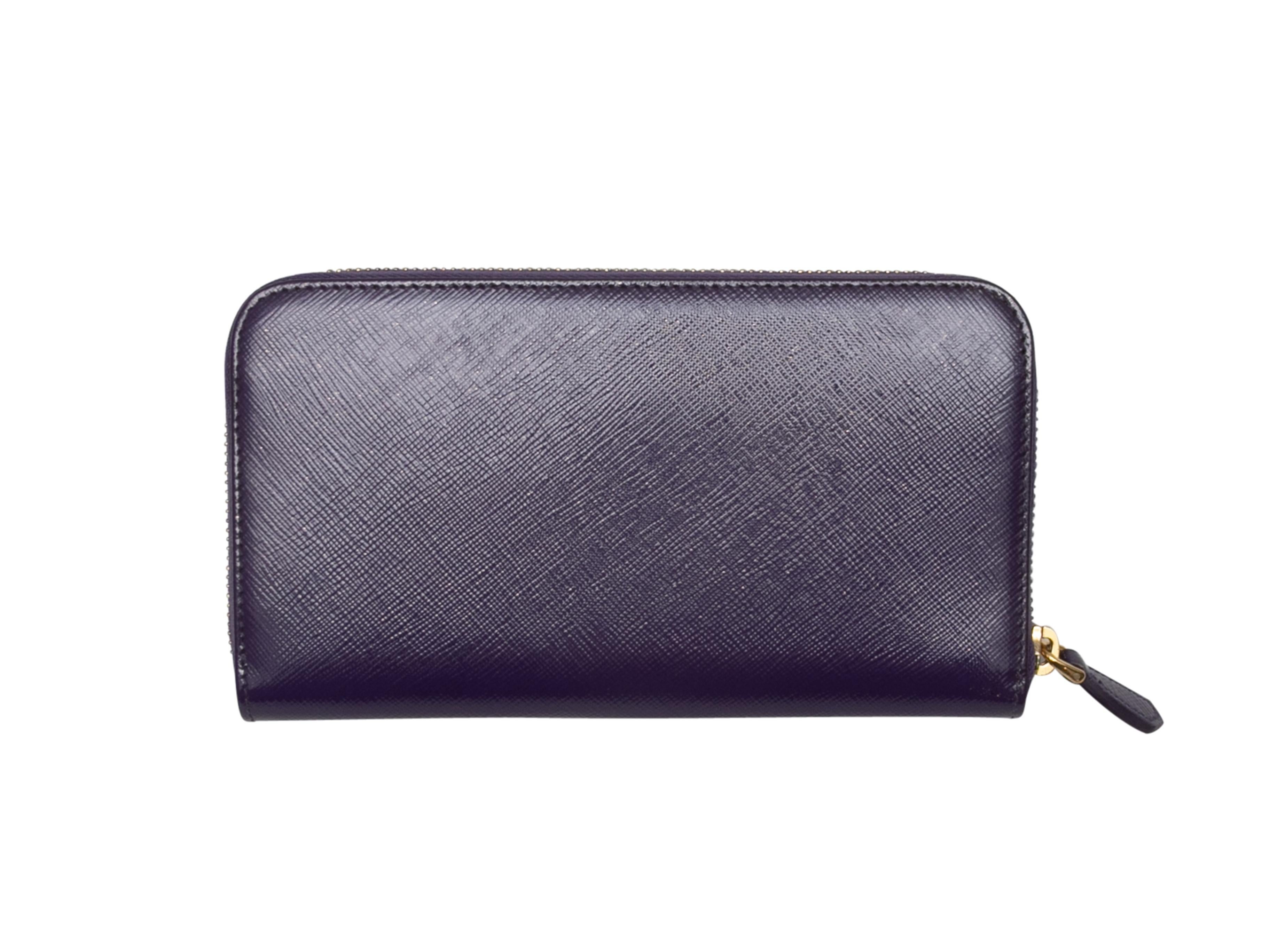 Product Details: Purple patent Saffiano leather Fiocco continental wallet by Prada. Gold-tone hardware. Bow accent at front. Top zip closure. 4.5