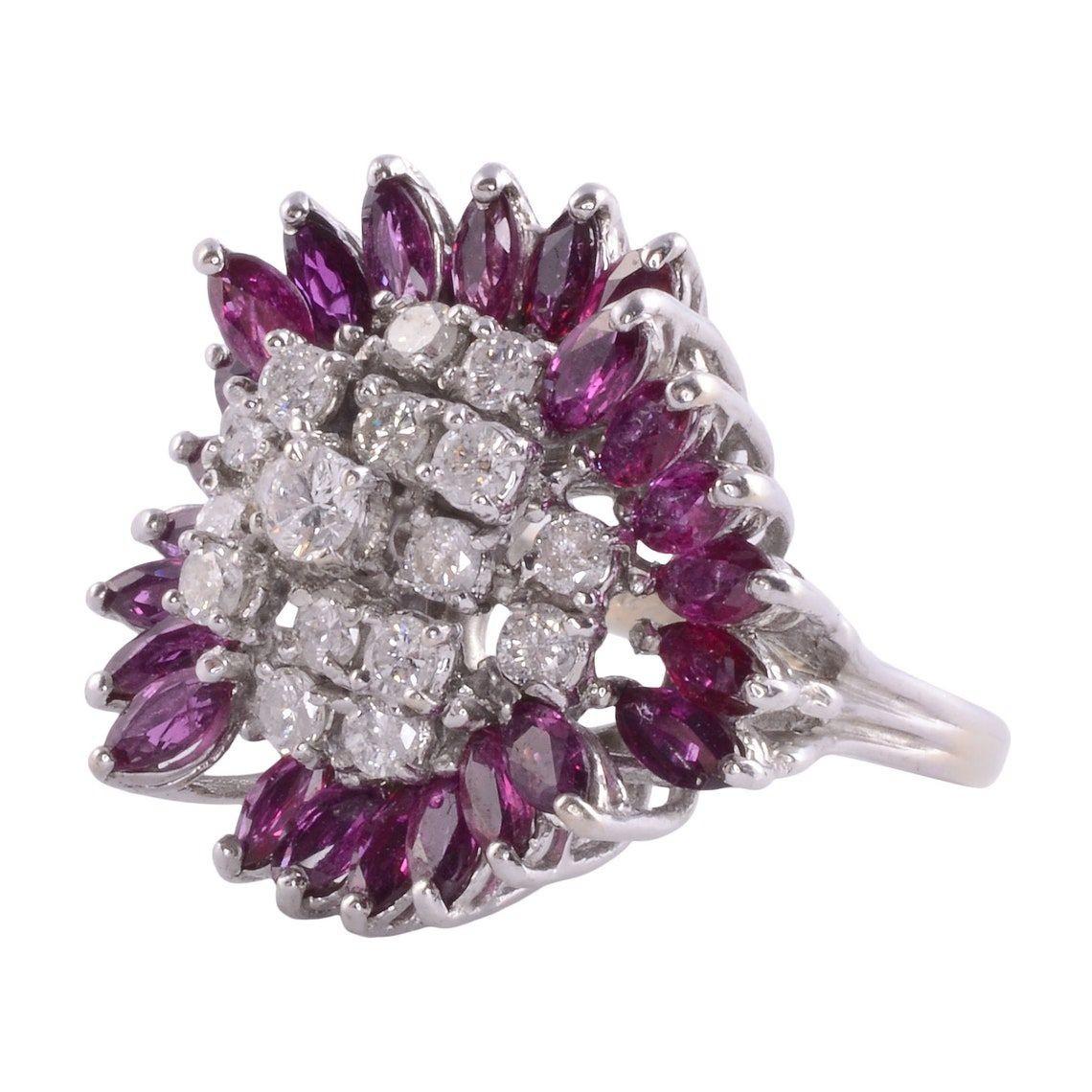 Estate purple red sapphire & diamond white gold ring. This 14 karat white gold ring features a basket setting with 24 purple red marquise sapphires at .80 carat total weight and 17 round diamonds at .81 carat total weight. The diamonds have I1-2