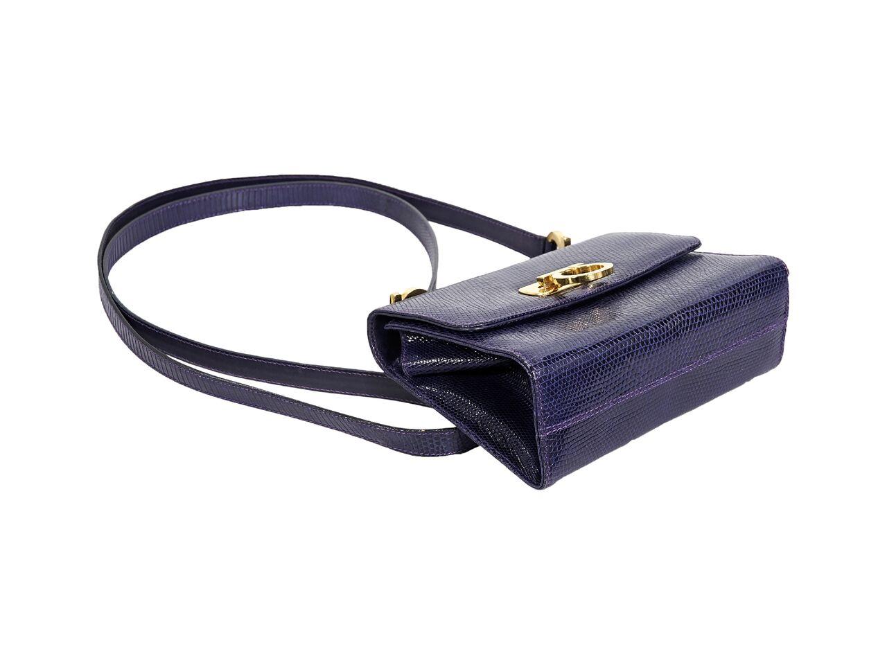 Product details:  Purple lizard crossbody bag by Salvatore Ferragamo.  Single crossbody strap.  Front flap with flip-lock closure.  Lined interior with inner slide pocket.  Goldtone hardware.  6.25