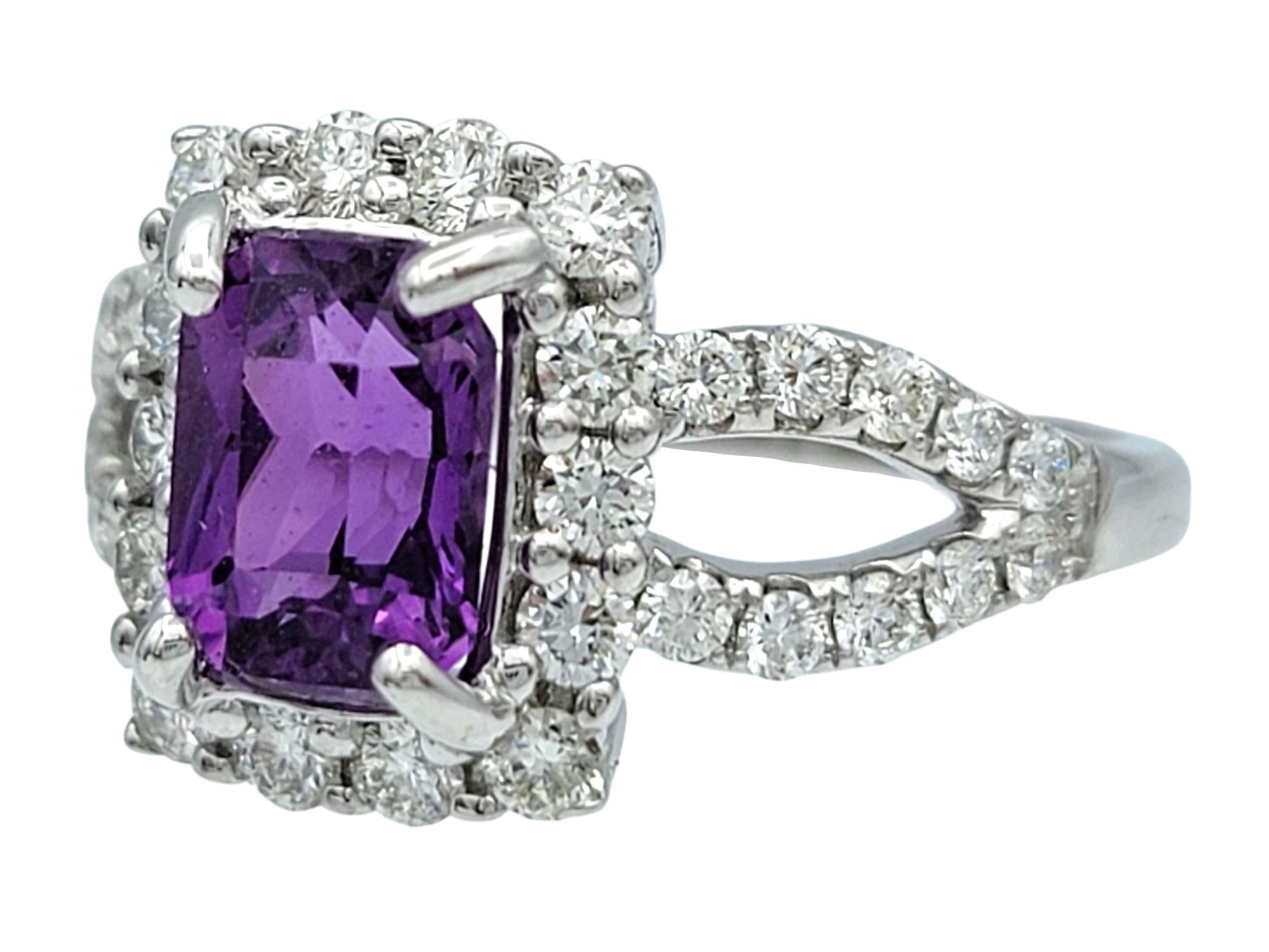 Ring Size: 5.75

This dazzling ring centers around a richly hued 1.78 carat purple sapphire, cut in an elegant rectangular shape that exudes regality and depth. Surrounding the sapphire is a glittering halo of white diamonds, which enhances the