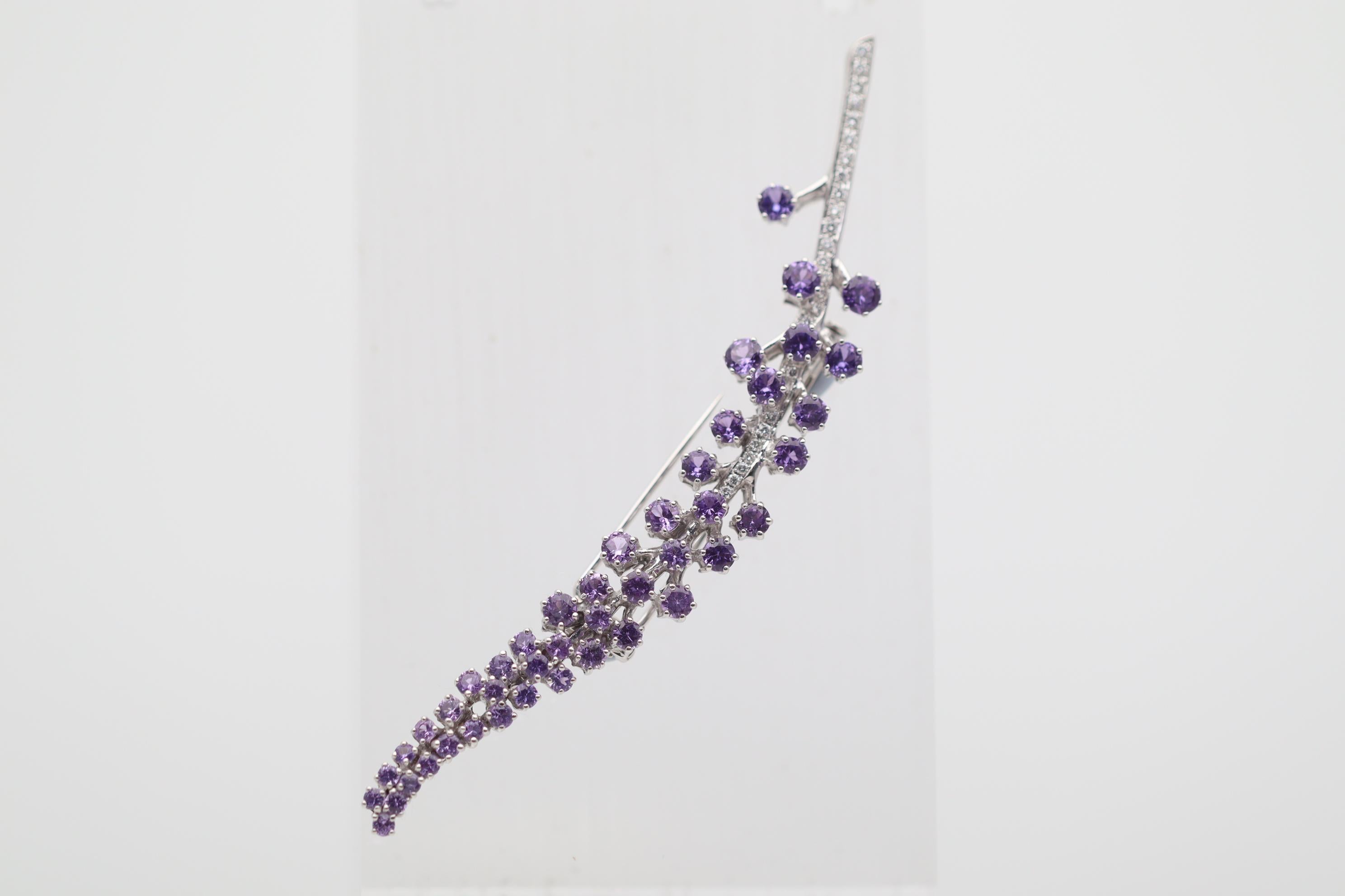 A chic and elegant brooch featuring fine purple sapphires, weighing approximately 4 carats. They are round brilliant-cut and graduate in color from a rich vivid purple color to a softer bright violet color on its end. Adding to that are 0.58 carats
