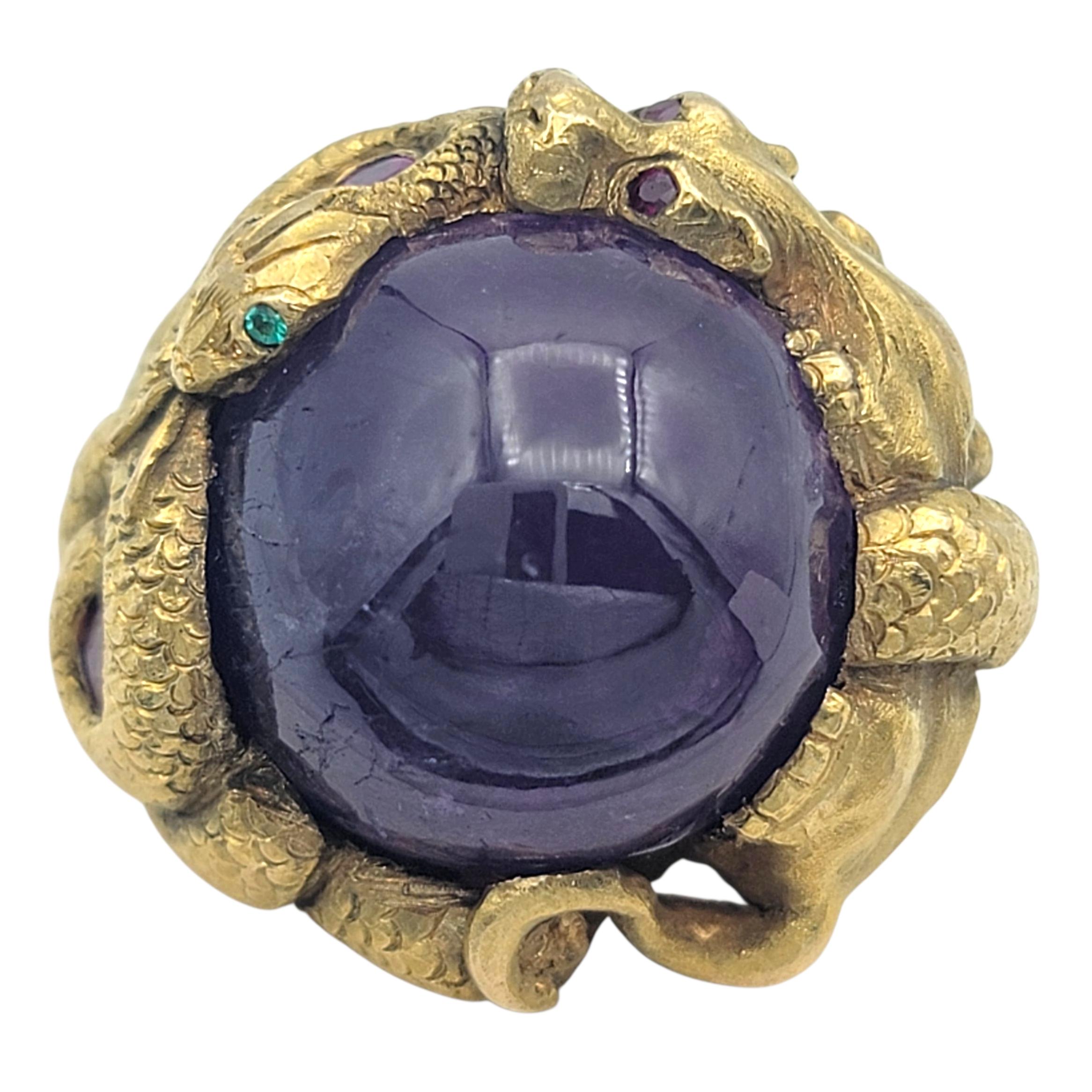 Questo straordinario anello è una vera e propria dichiarazione di maestria e design audace. Al centro si trova un magnifico zaffiro cabochon di colore blu-viola intenso, la cui superficie a cupola emana un bagliore ipnotico, quasi celestiale. La