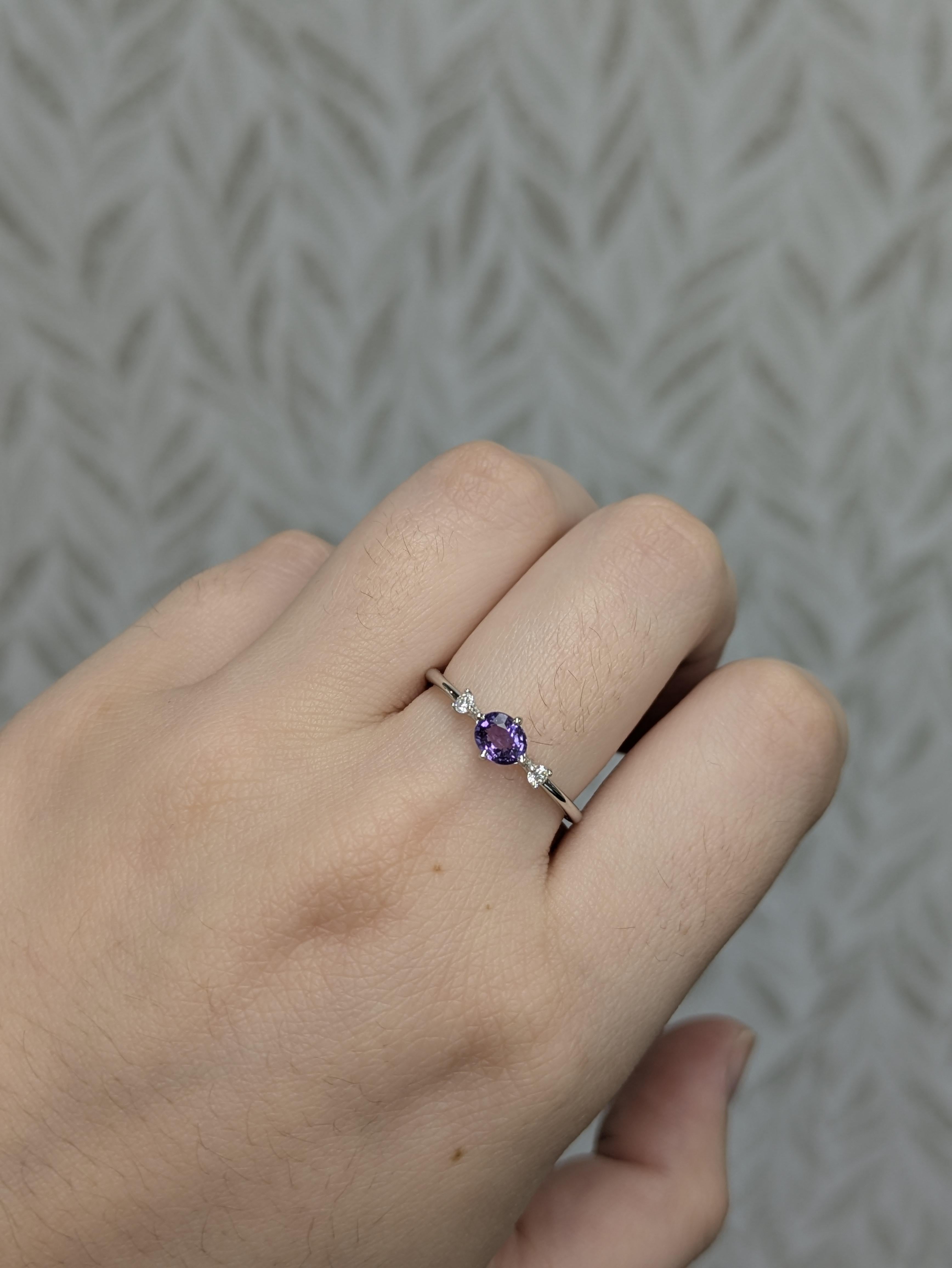 Este elegante anillo lleva un zafiro púrpura ovalado de 0,5 ct (5x4 mm), tratado térmicamente y procedente de Ceilán, conocido por producir zafiros finos. Engastado en 1,52 g de oro de 14 quilates, está acentuado con dos brillantes diamantes (0,07