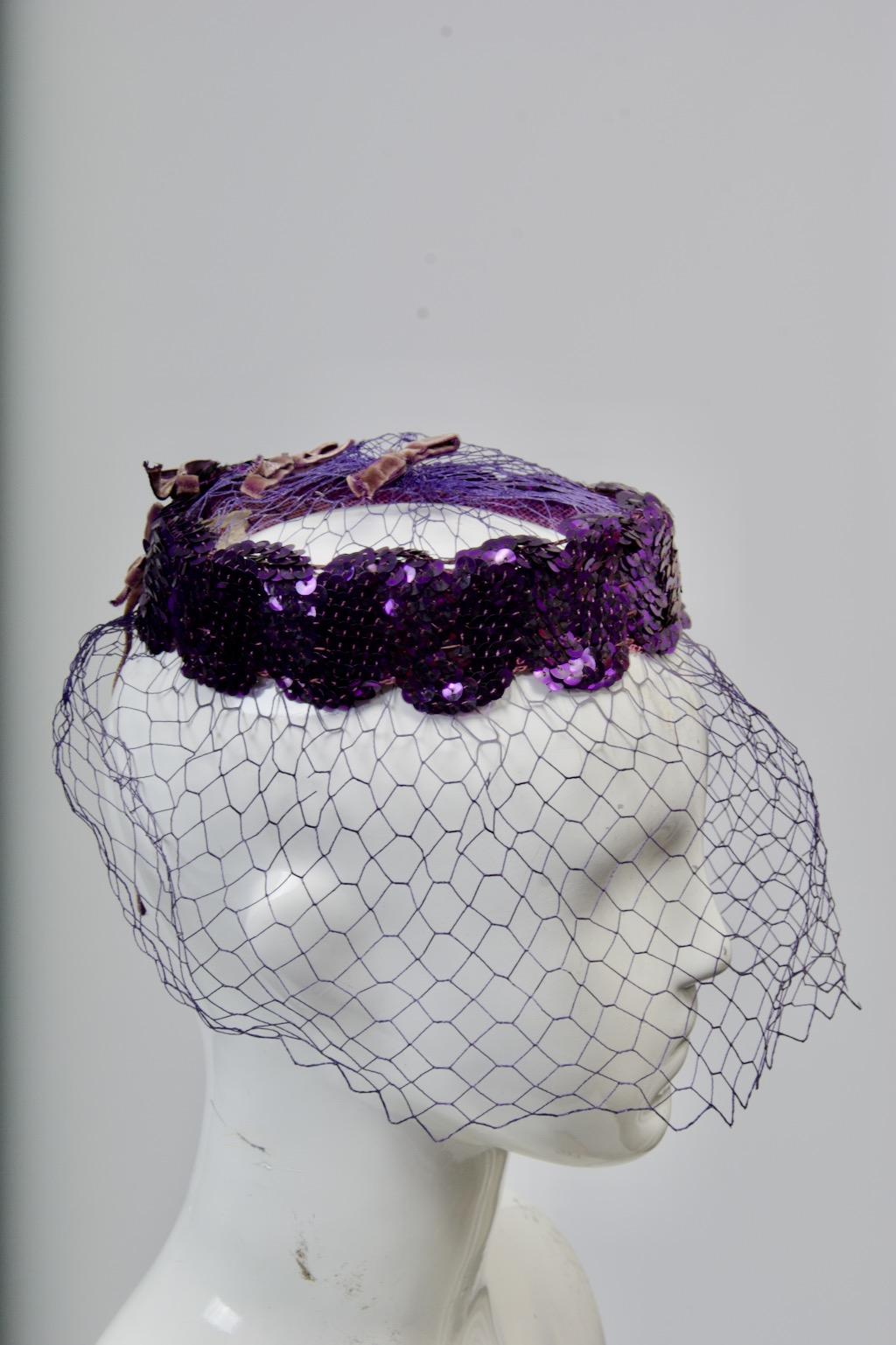 c.1950s pillbox-shaped headpiece with open crown and veil, the body composed of purple sequins in a serpentine design. Small velvet bows adorn the crown and back.