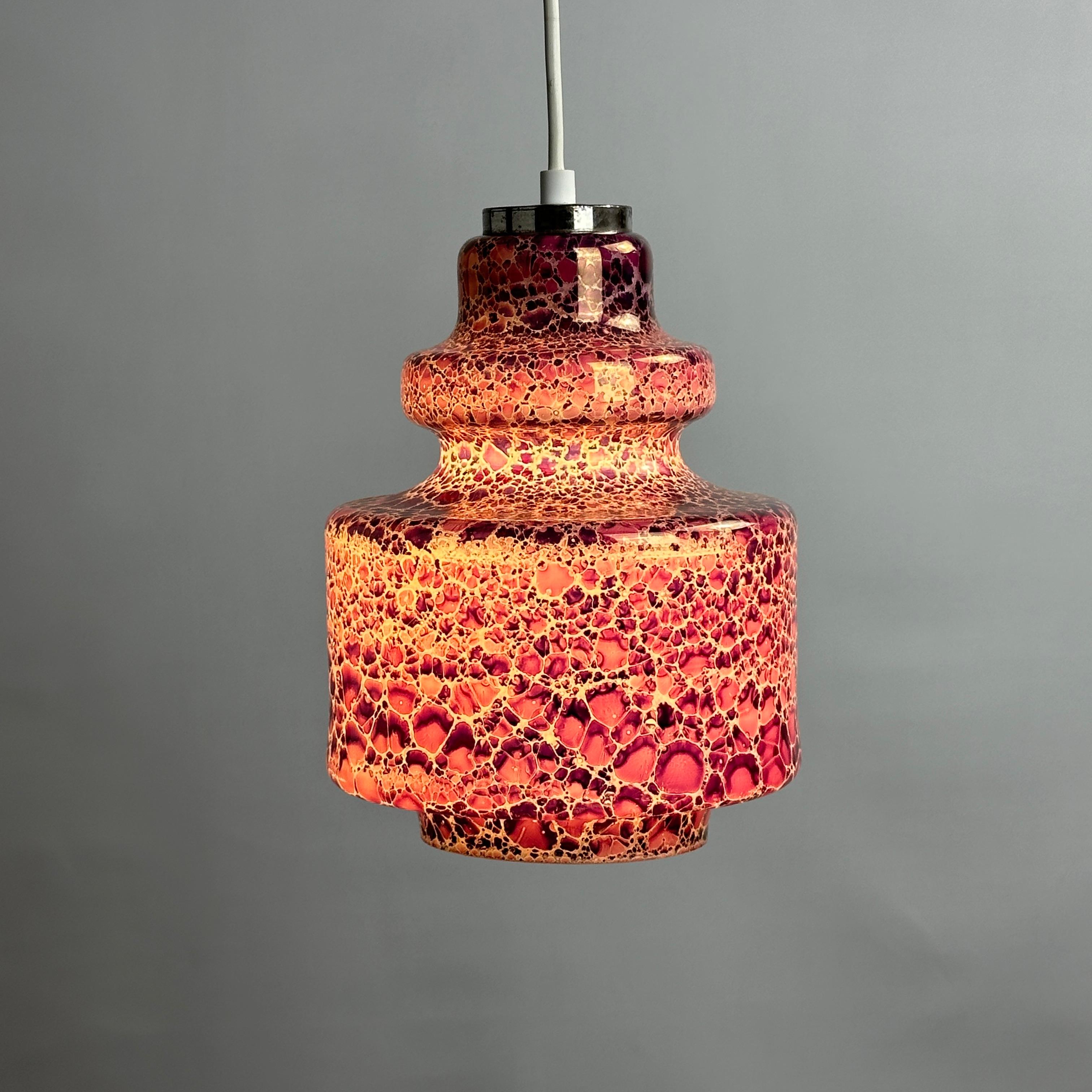 Dieses wunderbare Stück niederländischer Handwerkskunst der Firma Herda wurde um 1970 hergestellt. Die Lampe besteht aus Opalglas und hat ein Schlangenhautmuster. Wenn sie eingeschaltet ist, leuchtet die violette Farbe
