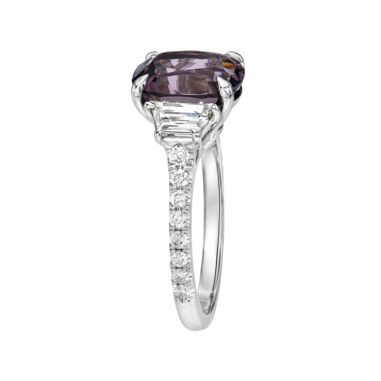 Exclusive 3.98 carat natural Purple Spinel cushion, three stone platinum ring, decorated with a pair of 0.66 carats, H color/VS clarity, trapezoid diamonds, and a total of 0.26 carats round brilliant diamonds.
Size 6. Re-sizing is complimentary upon