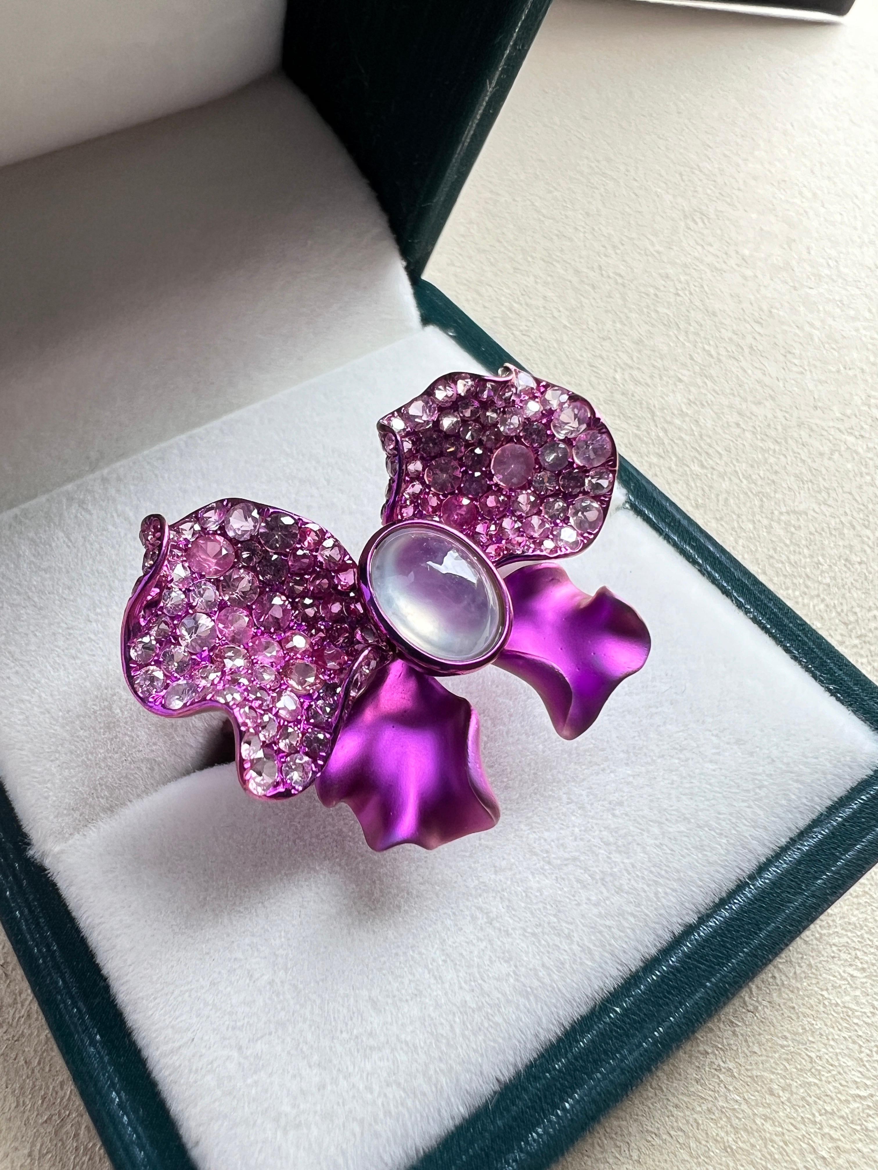 Description: Purple Titanium icy jadeite cabochon with pink sapphire ring

Material of mounting: 100% Titanium 
Center stone  Dimension approx (mm):  9*7*5mm (icy white cabochon)
pink sapphire: 127 pcs , total 3.66cts
Transparency: Transparent (Icy