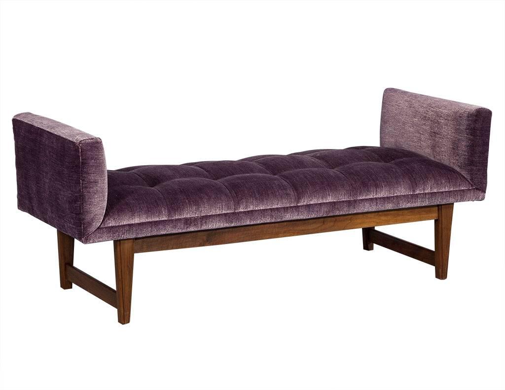 Purple velvet Mid-Century Modern bench settee. This Gorgeous bench is newly reupholstered in a luminous purple velvet. Featuring a channel upholstered seat, and bolster rolls on the ends for added comfort. This bench sits atop a solid wood base,