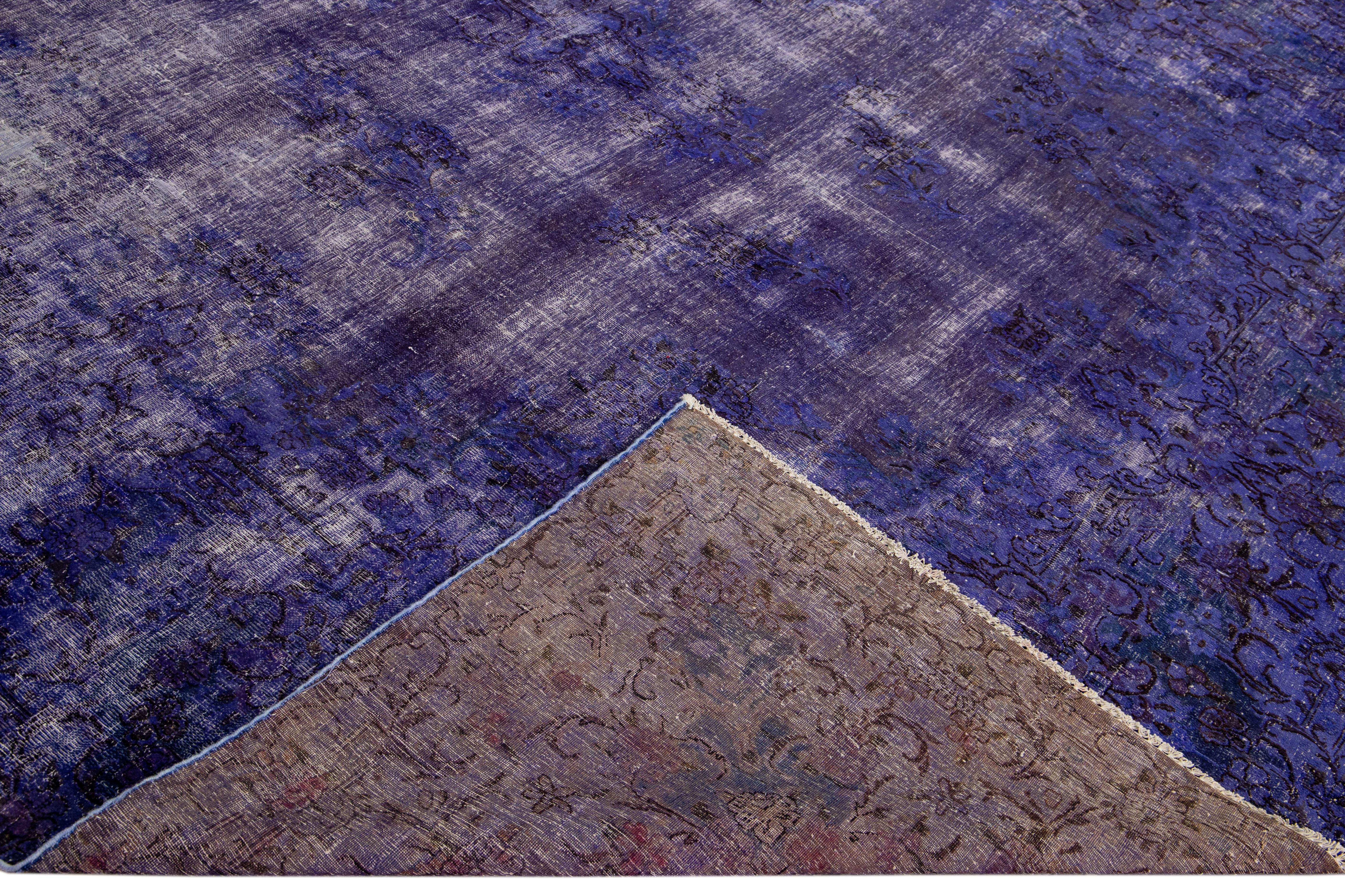 Magnifique tapis vintage en laine surdimensionné, noué à la main, avec un champ violet. Ce tapis surteint présente des accents ivoires et bruns dans un motif floral intégral.

Ce tapis mesure : 9'8' x 15'7