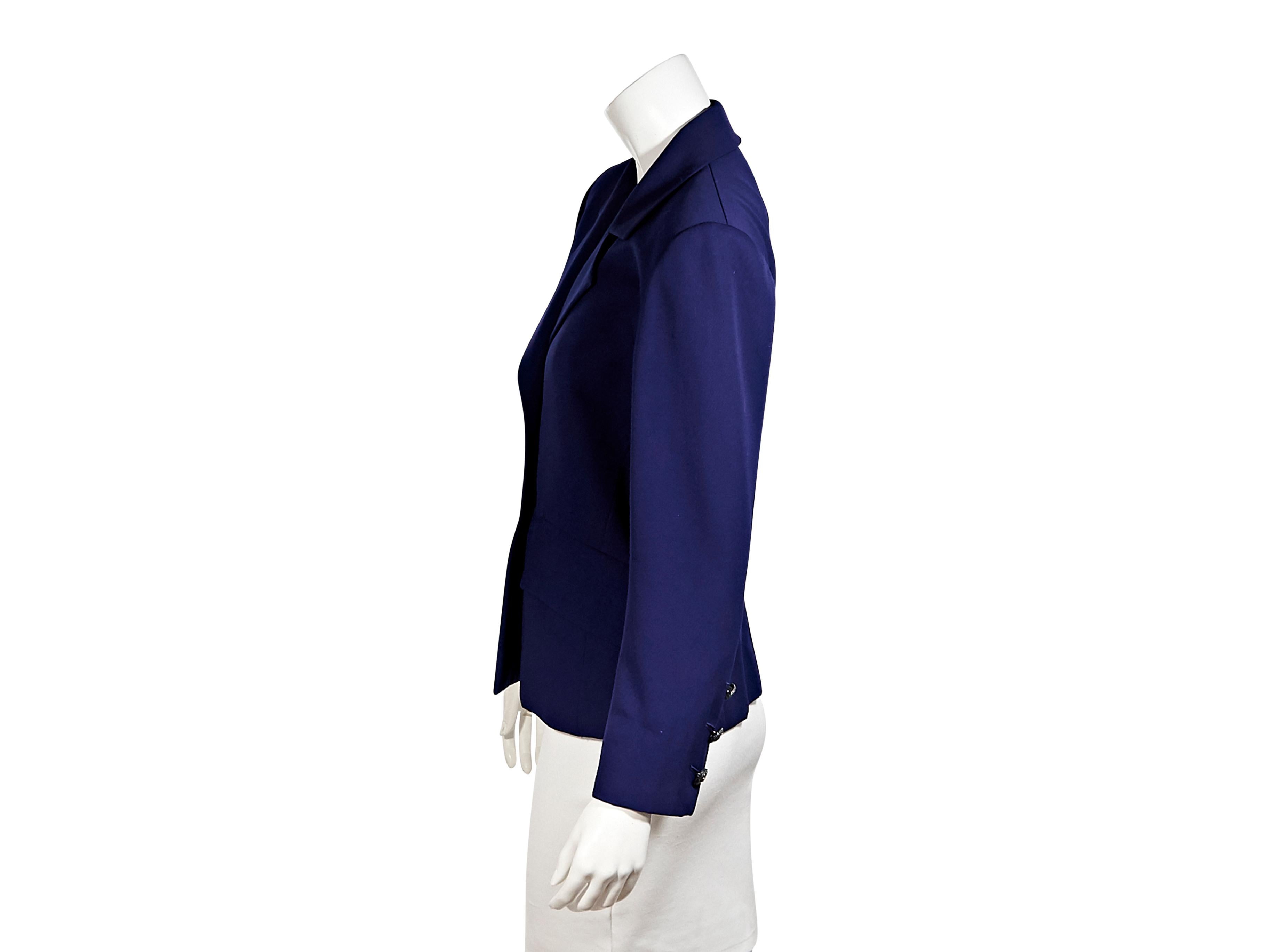 Product details:  Vintage purple blazer by Saint Laurent Rive Gauche.  Notched lapel.  Long sleeves.  Three-button detail at cuffs.  Button-front closure.  Waist flap pockets.  Silvertone hardware.  40