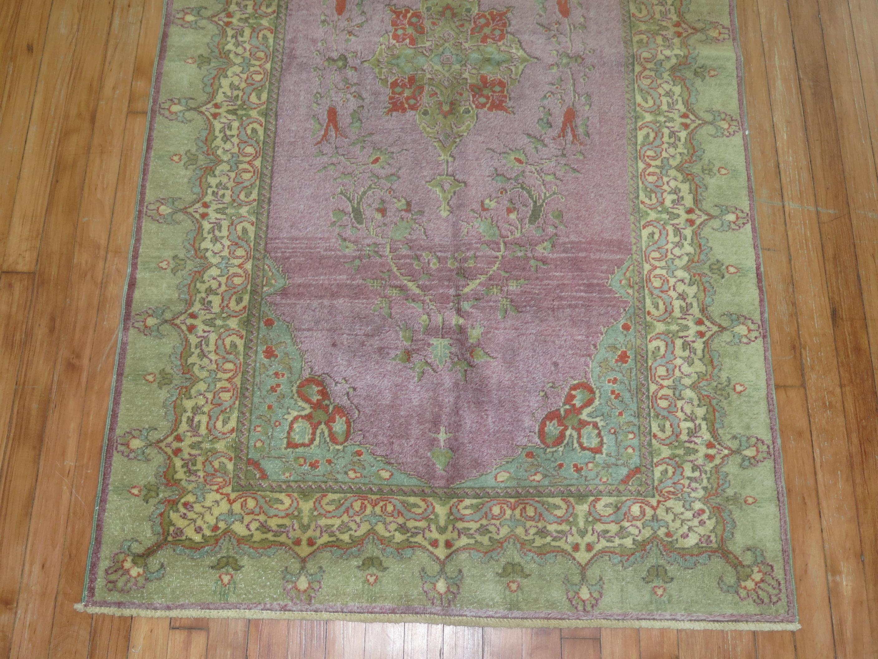 A one of a kind decorative Turkish rug with a formal feminine floral design in purple and light green.