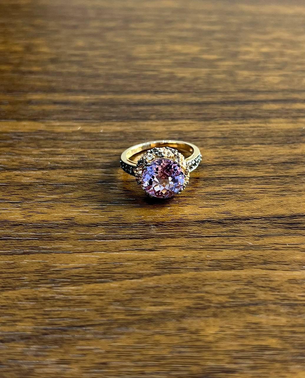 A study in elegance, color, and brilliance.

This captivating ring features a stunning, round-cut purple violet amethyst at its center. The vibrant stone is encircled by a halo of sparkling white diamonds and gemstones, enhancing its radiant allure.