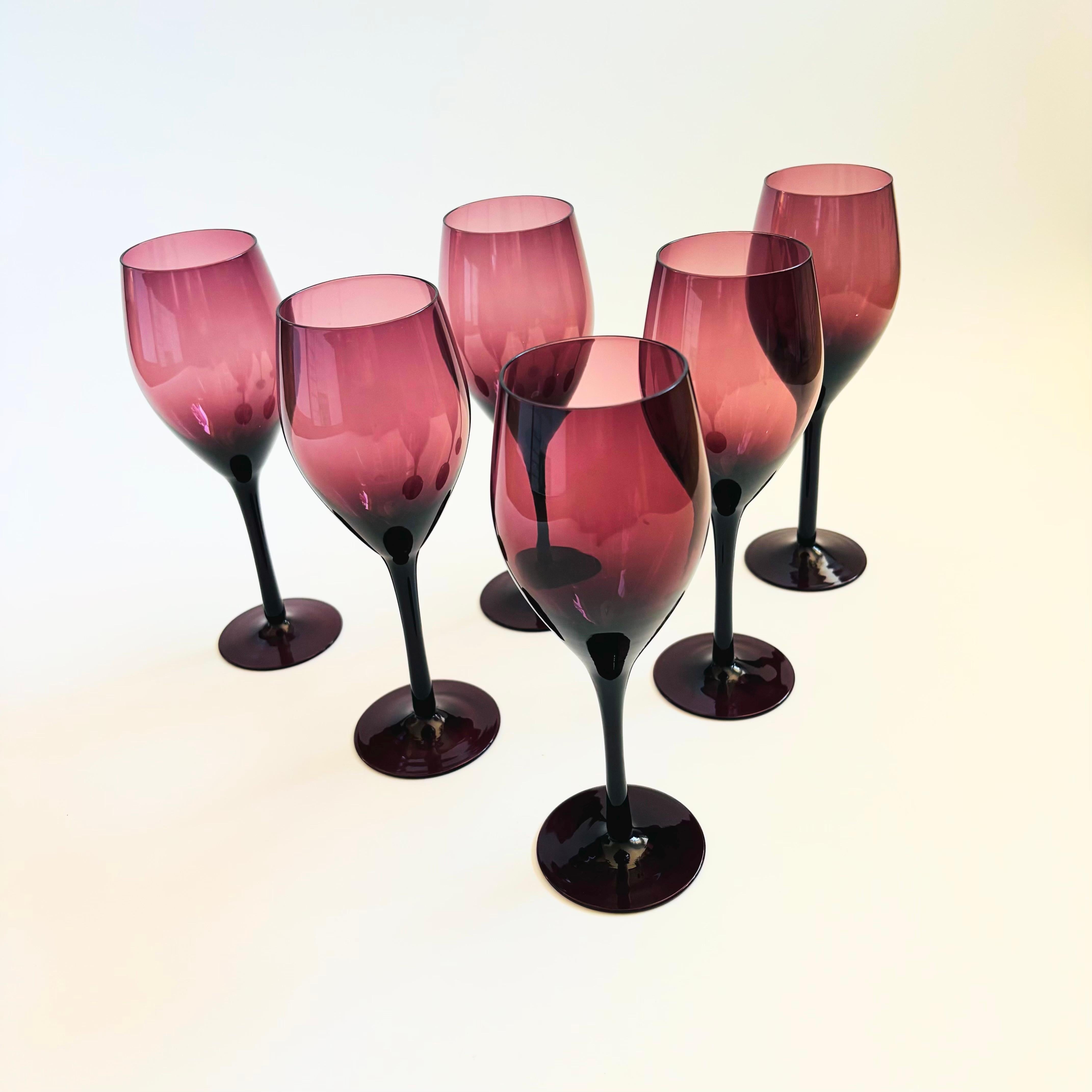 Un delizioso set di 6 bicchieri da vino vintage. Realizzato in vetro viola scuro. Eleganza degli steli affusolati.

