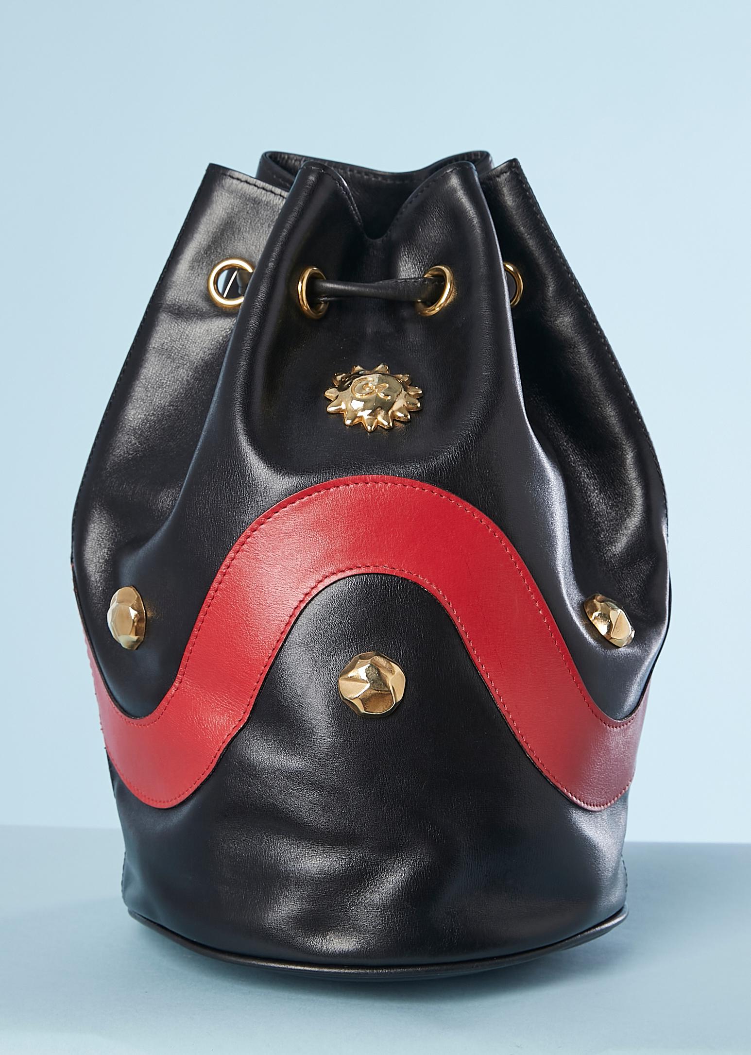 Purse bag in red and black leather with gold metal cabochon embellishement. ONe flat pocket inside. Silky gros-grain lining.
Dust-bag provide