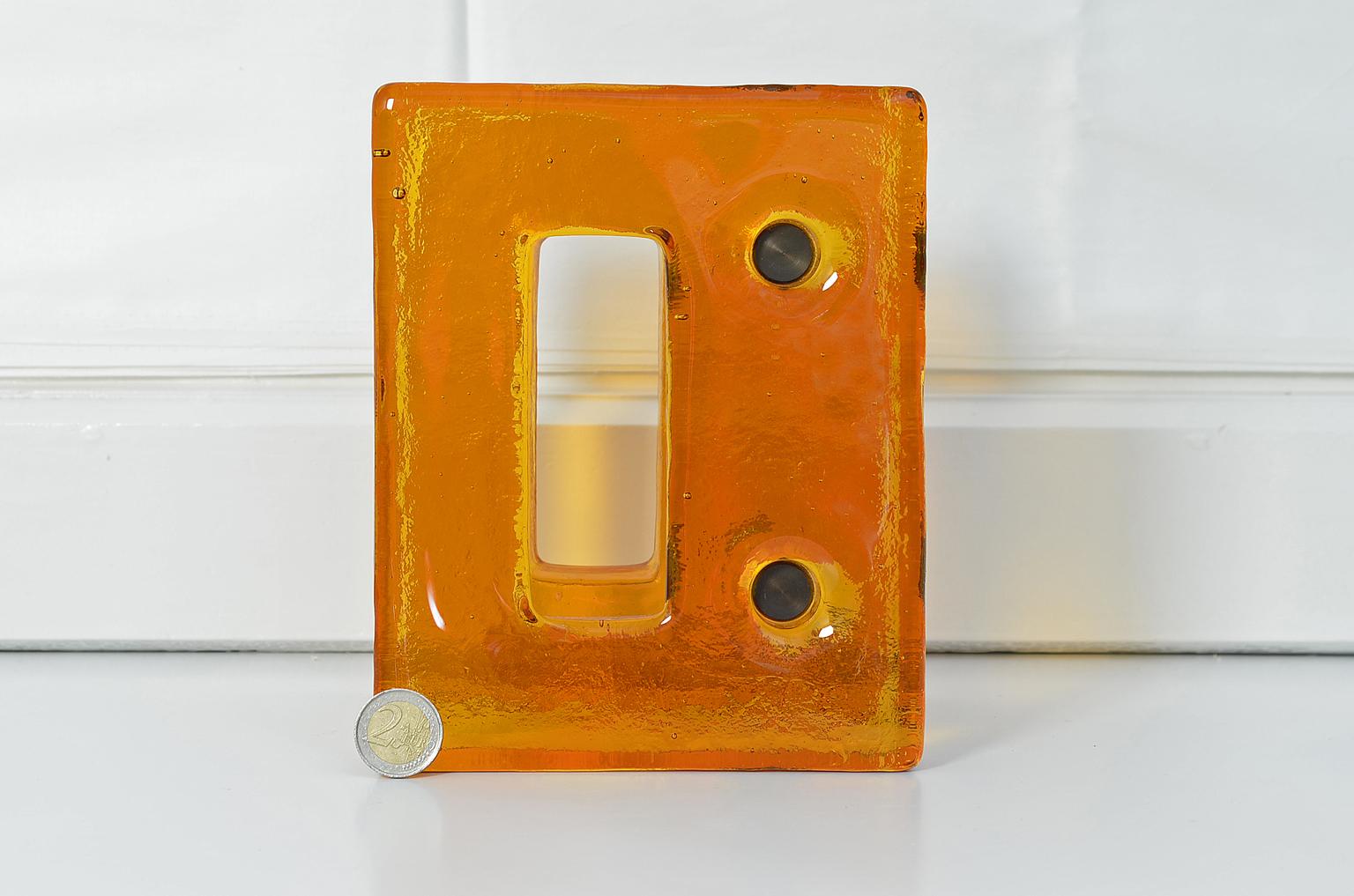 Push and pull door handle in orange glass with brass fittings, France, 1970s.