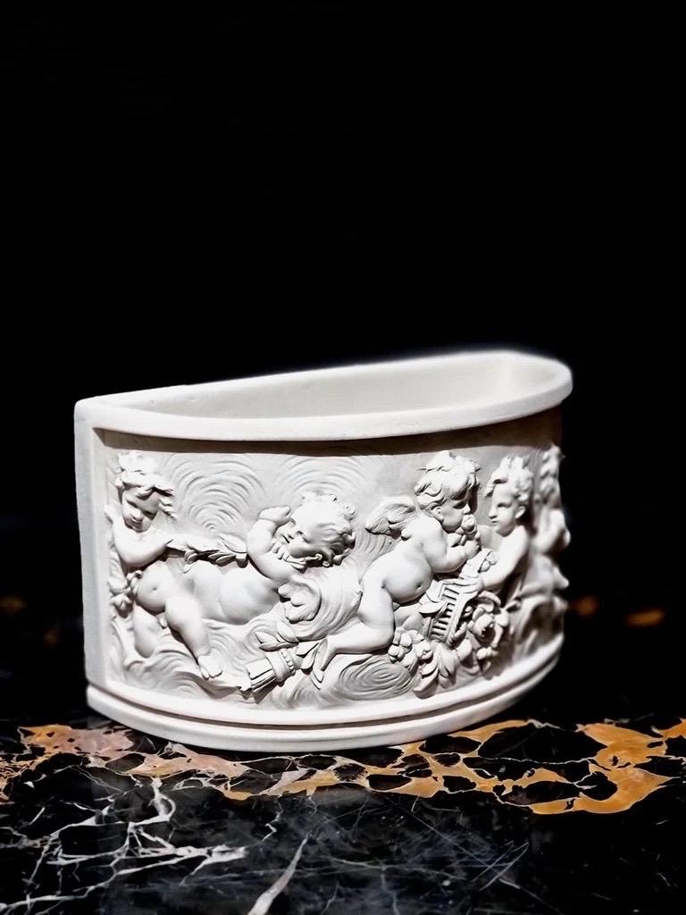 A Putti Console Vase is an ornate and decorative vase often associated with classical and Rococo design styles, typically featuring playful **putti** (cherubic, child-like figures) as key decorative elements. These figures are sculpted in bas-relief