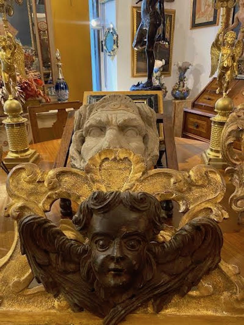 Sculpture de putto ailé d'origine italienne de 1750 représentant le visage d'un ange en bois sculpté provenant d'un ornement liturgique auquel il était fixé par deux clous,  on peut encore voir les trous dans la partie inférieure du plumage de