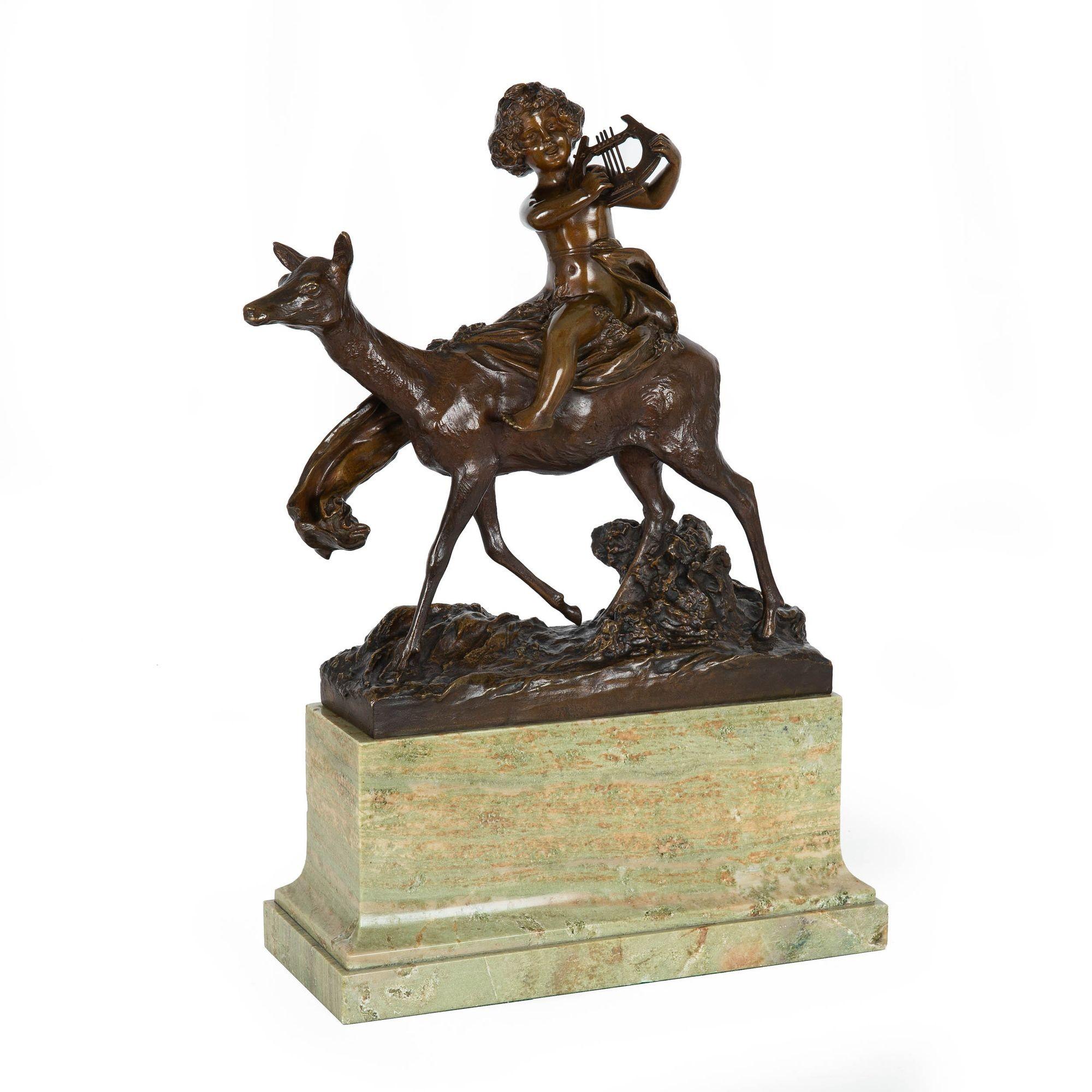 A very fine lifetime casting of Charles Korschann's Putto Riding a Doe, the model is steeped in the elements of the Art Nouveau with a distinct celebration of the naturalistic. The putto grasps a simple harp in his hand while a loose garment bound