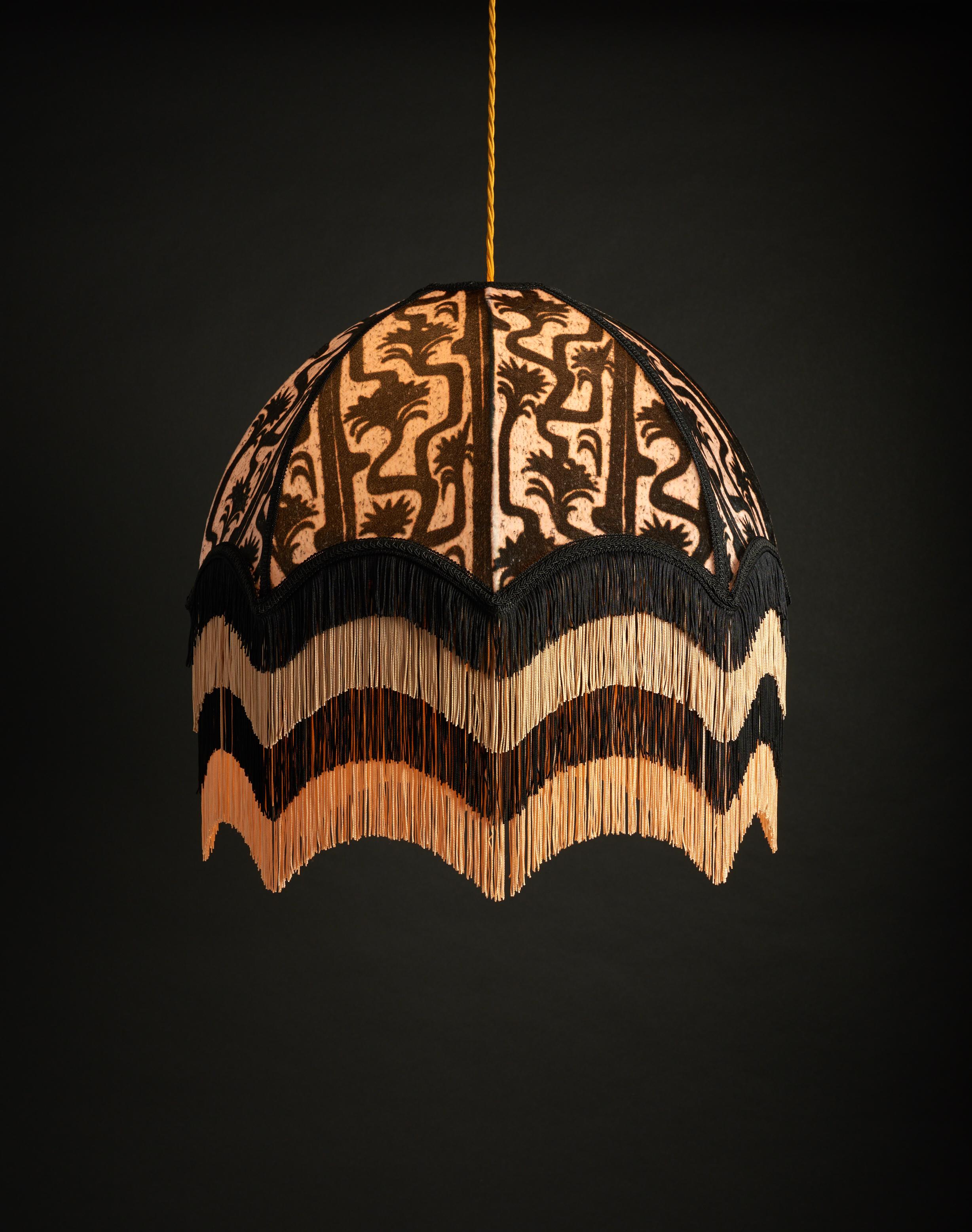 Puzzle was created as a linoprint which has been digitally worked into an offbeat meandering tree pattern. In tones of soft black and blush with four layers of decadent fringe.

Anna Hayman lampshades create a fantastic centrepiece to a room and