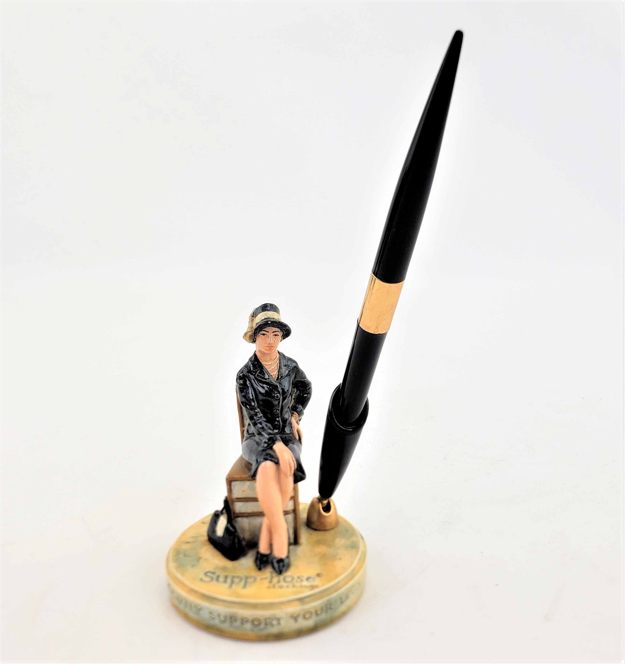 This advertising pend holder was produced by P.W. Baston, also known as Sebastian Miniatures, of the United States in approximately 1960 in the period Mid-Century Modern style. The figurine is composed of a glazed ceramic with a brass and plastic