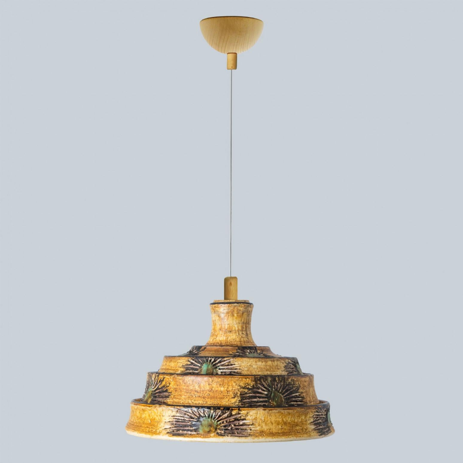 Stunning round hanging lamp with an unusual shape, made with rich brown and yellow colored ceramics, manufactured in the 1970s in Denmark. We also have a multitude of unique colored ceramic light sets and arrangements, all available on the