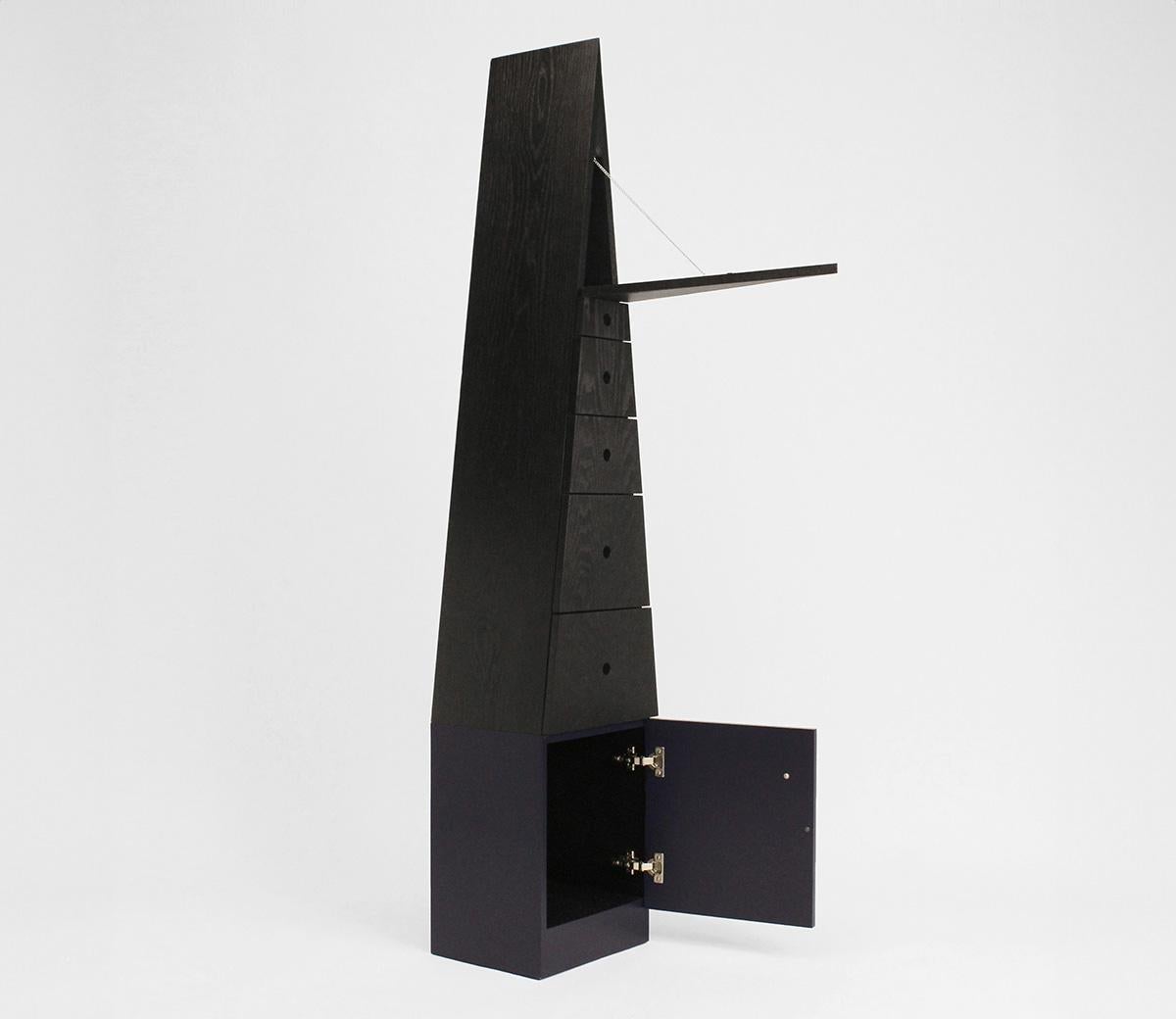 Con un'altezza di oltre due metri, la silhouette drammatica di Stave Cabinet vive nello spazio come un campanile o un obelisco con una presenza imponente ma pacifica. Le sue sottili variazioni di toni scuri, linee ordinate e metodi di costruzione